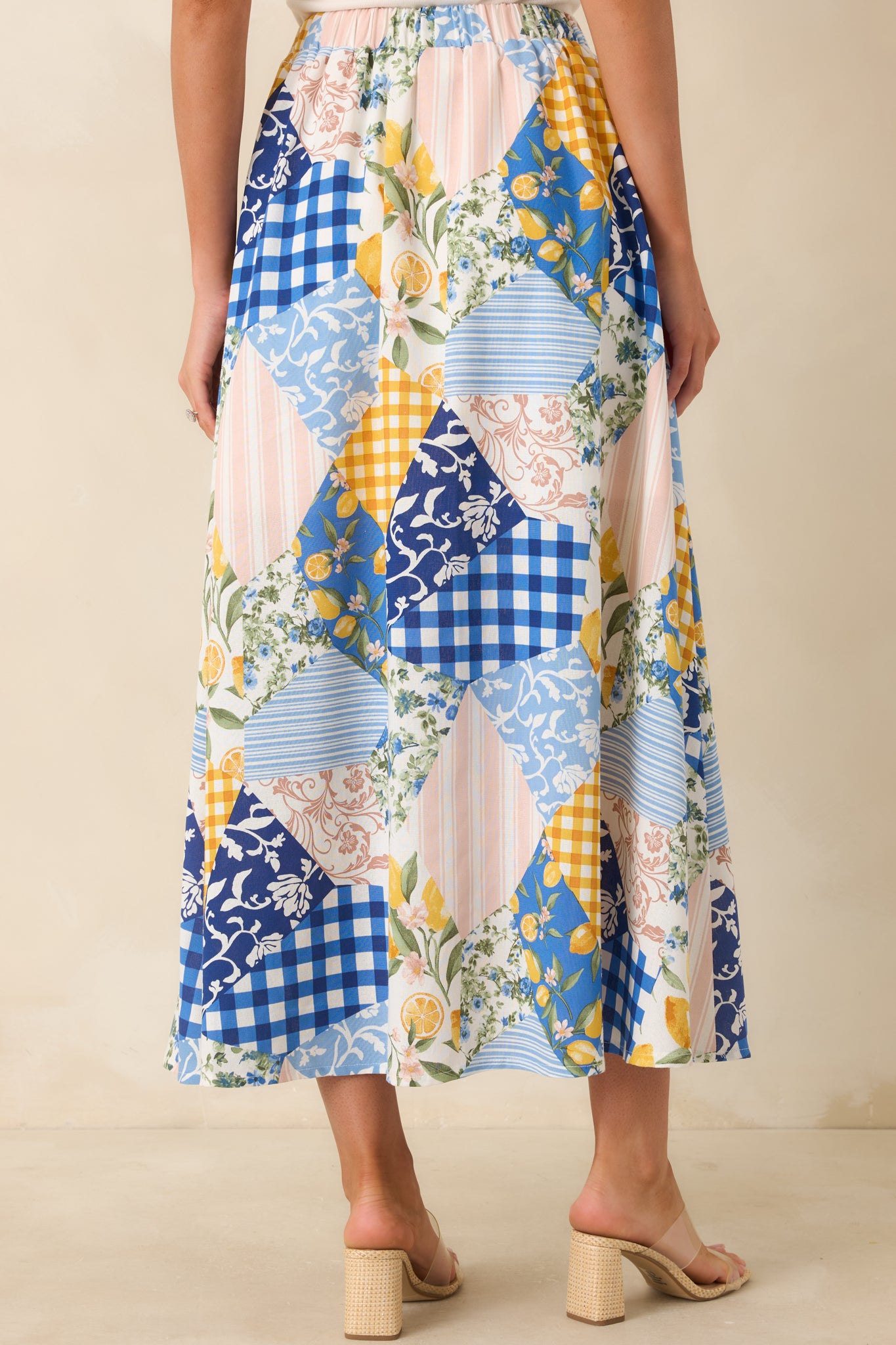 Rear view of multi-print patchwork midi skirt with elastic waistband and flowy silhouette.