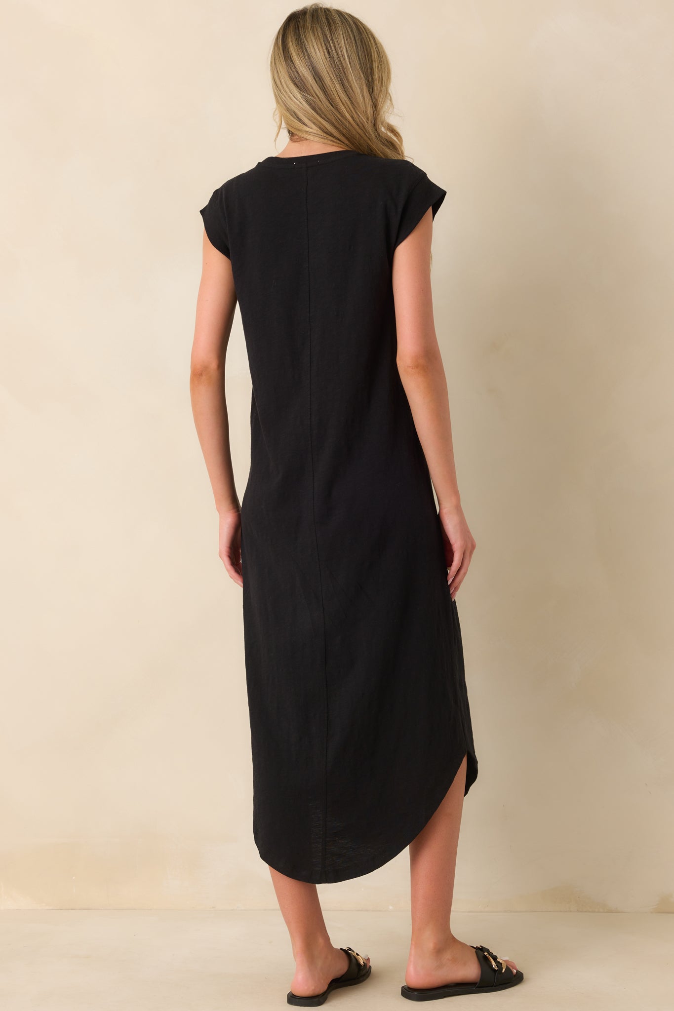 Rear view of black midi dress showing the back center seam detailing and relaxed fit. 
