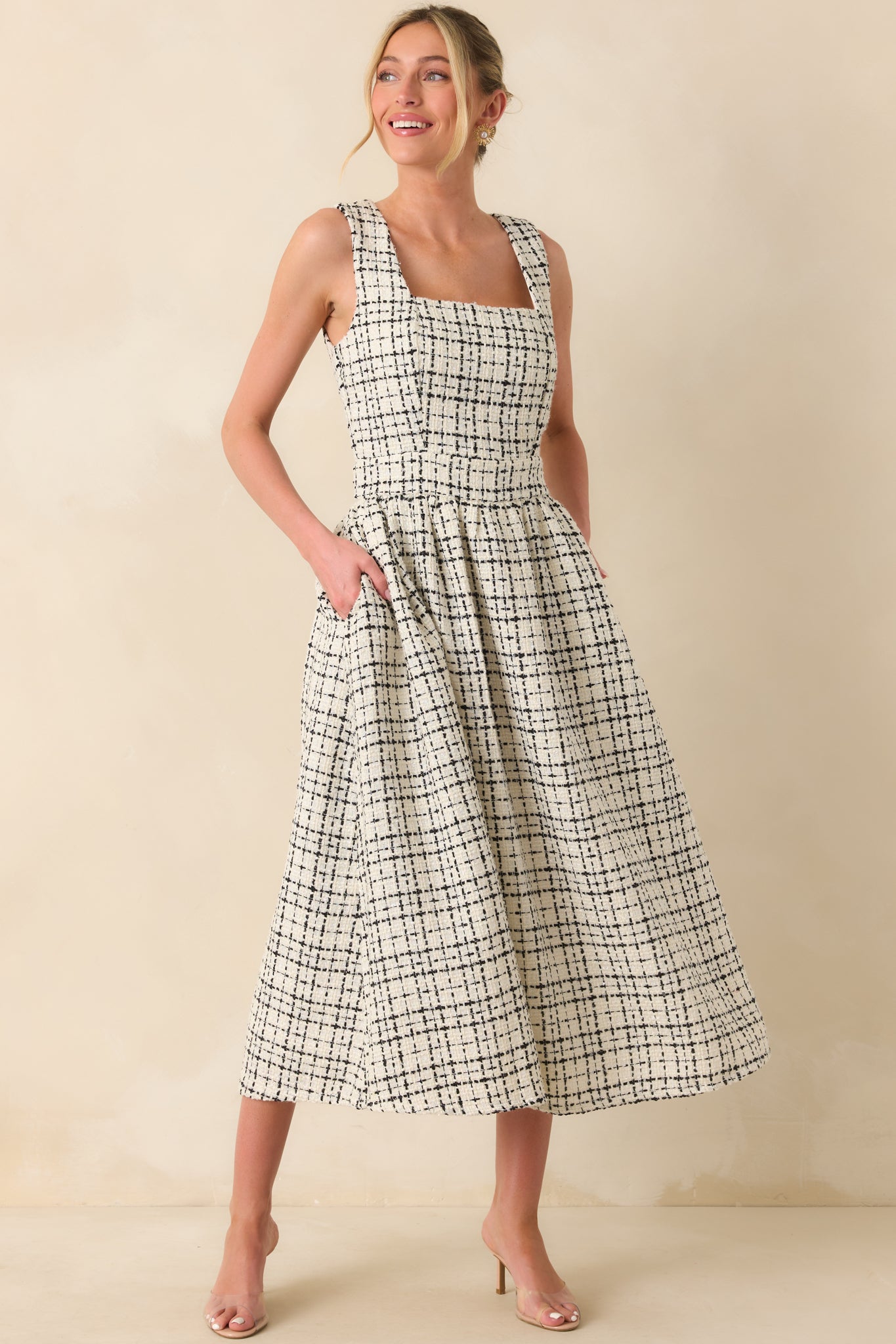A full body angle highlighting the tweed pattern and flared skirt of the midi-length dress.