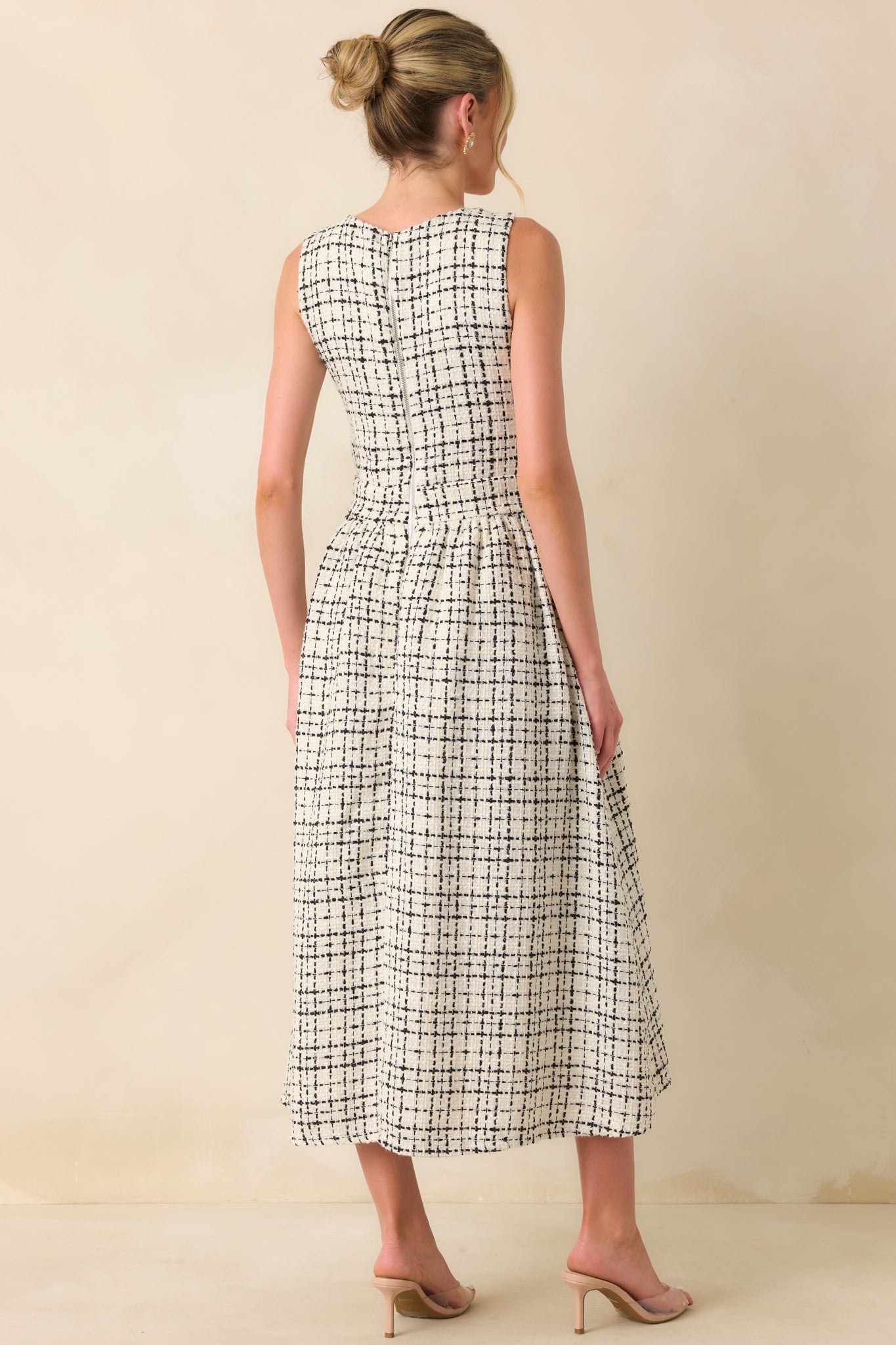 A back view of the dress featuring the discrete zipper closure, sleeveless design, and flared skirt.