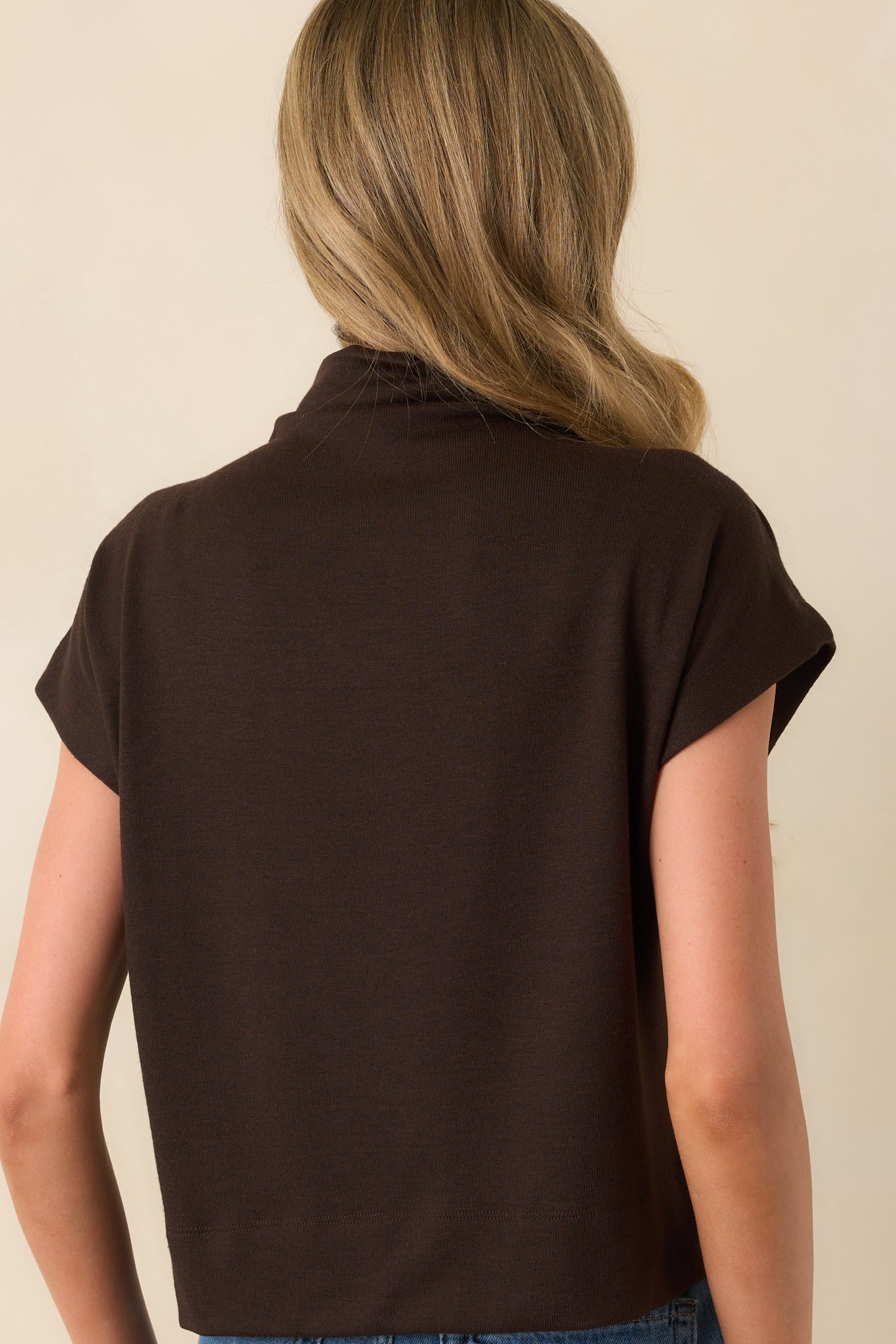 Rear view of the top displaying the smooth back panel and relaxed fit continuing through the back hem.