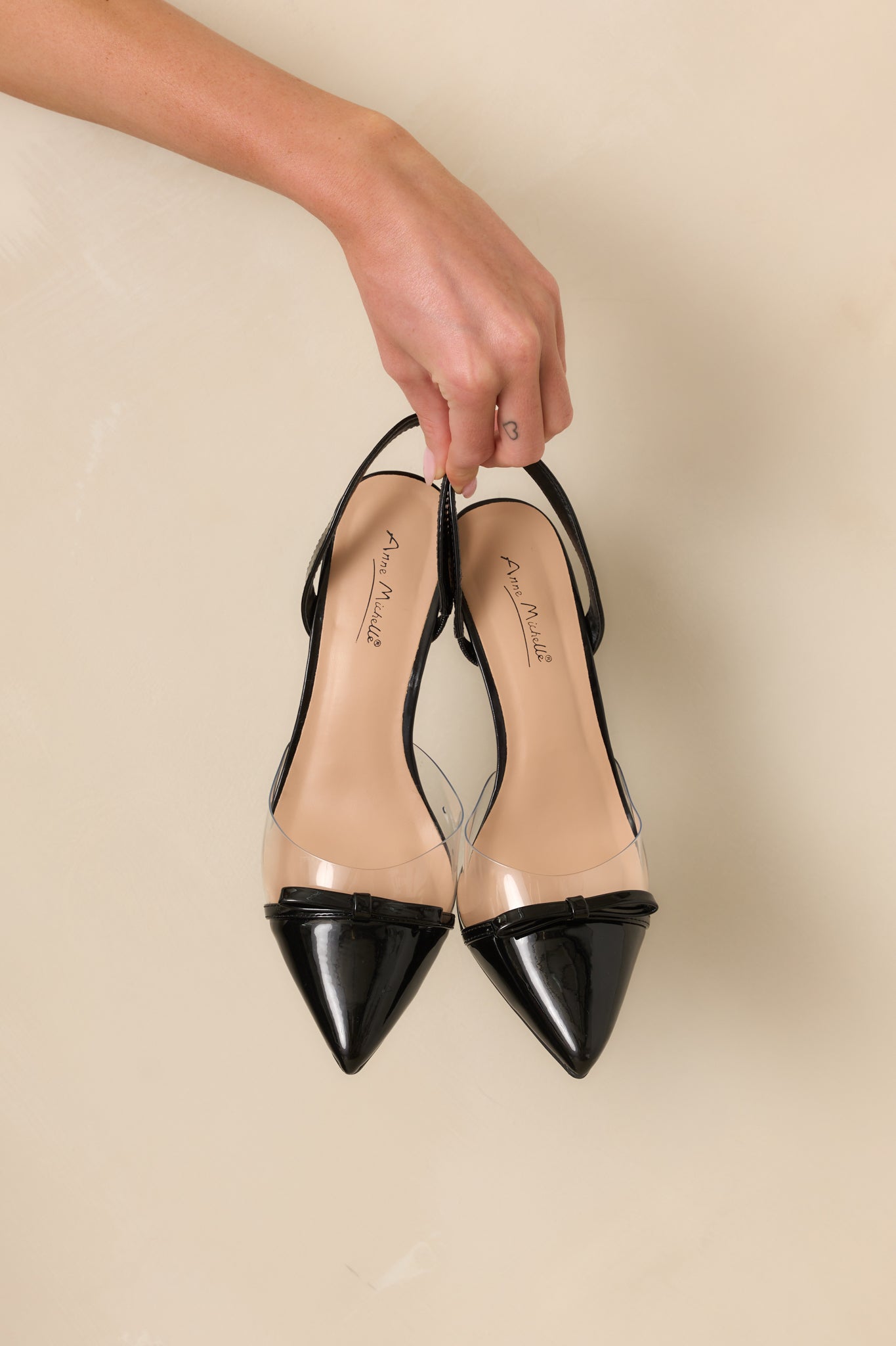Angled overhead view of the black kitten heels showing both shoes and bow detailing.