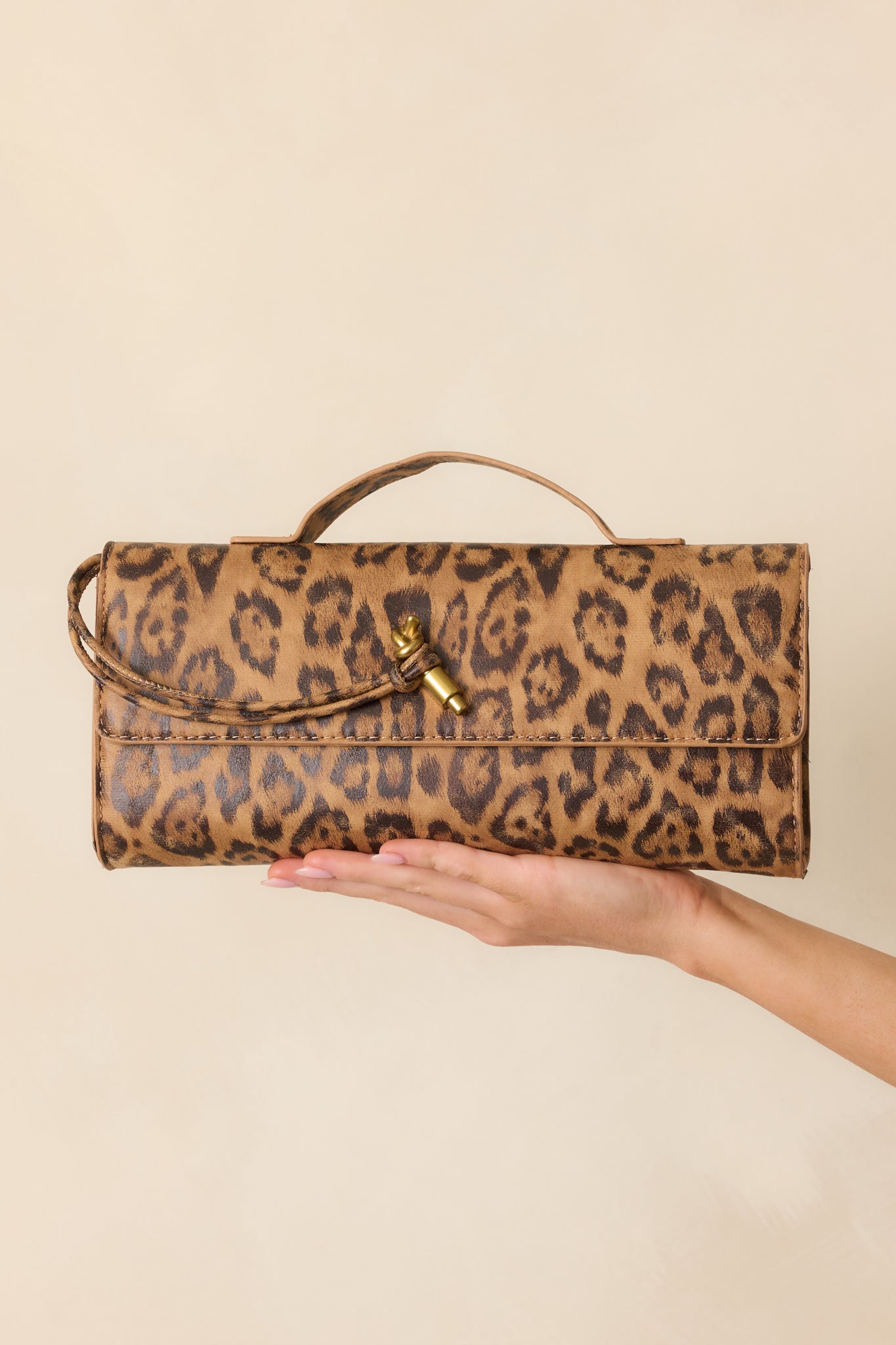 Detailed look at the textured leopard print material and polished gold clasp