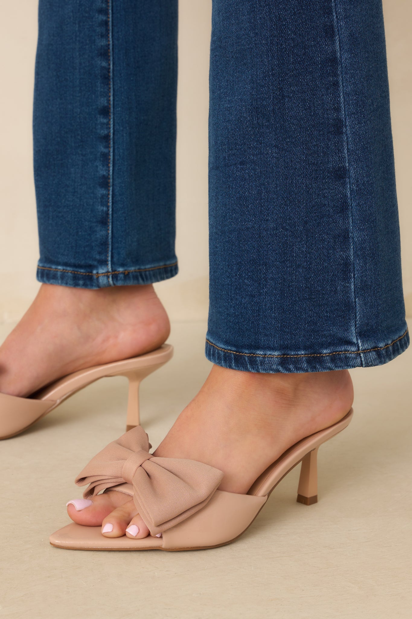 Close view highlighting the pointed toe shape and delicate bow placement on the strap.