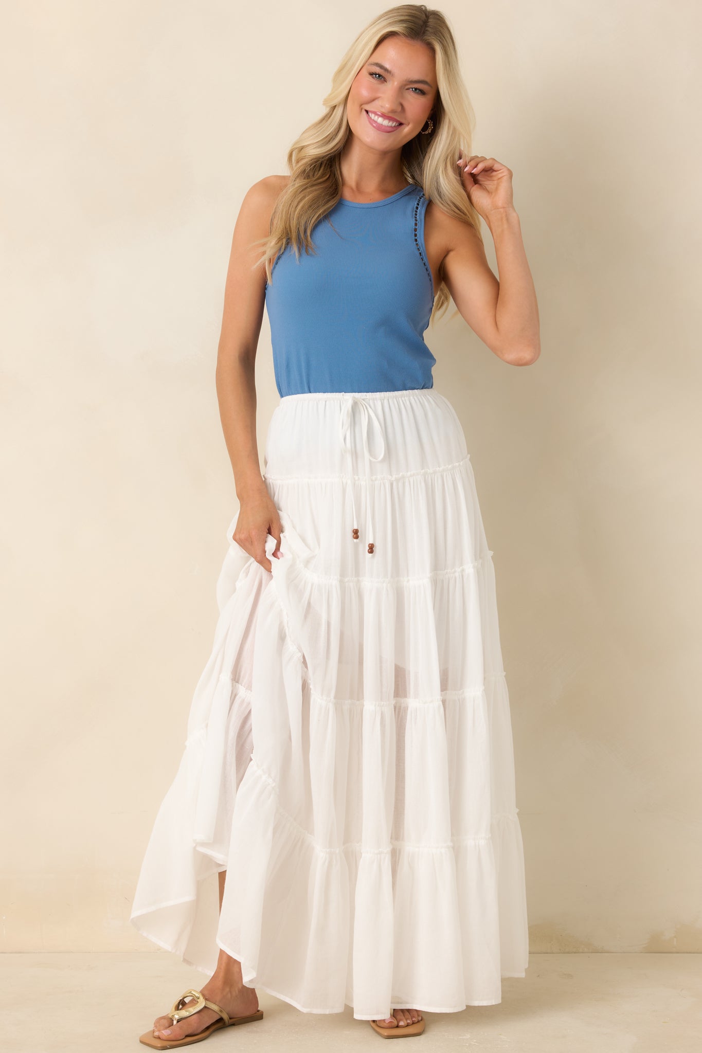 Ivory maxi skirt with elastic waistband, drawstring tie, and tiered silhouette.