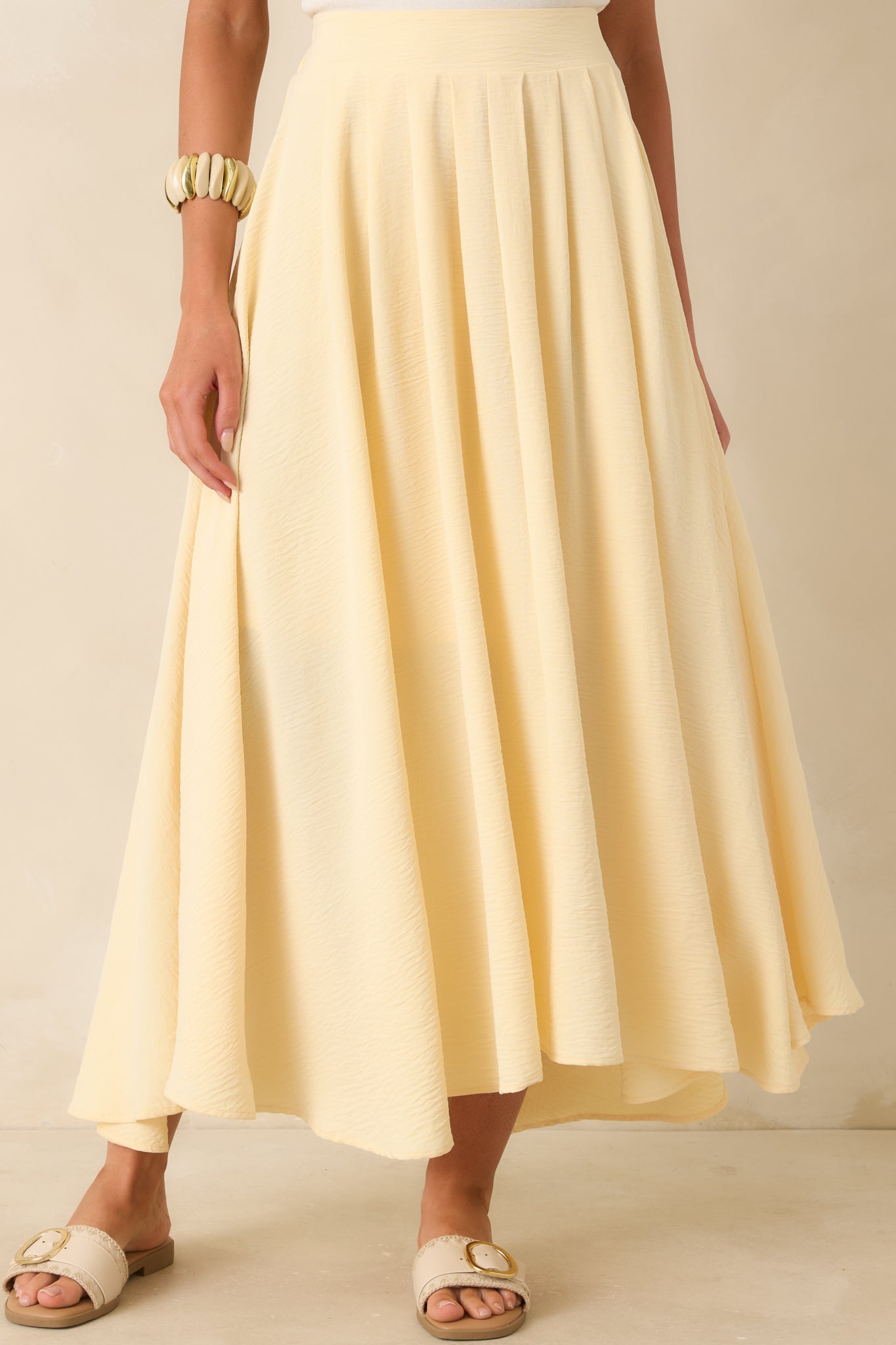 Cropped view of the light yellow maxi skirt highlighting the elastic waistband and airy silhouette.