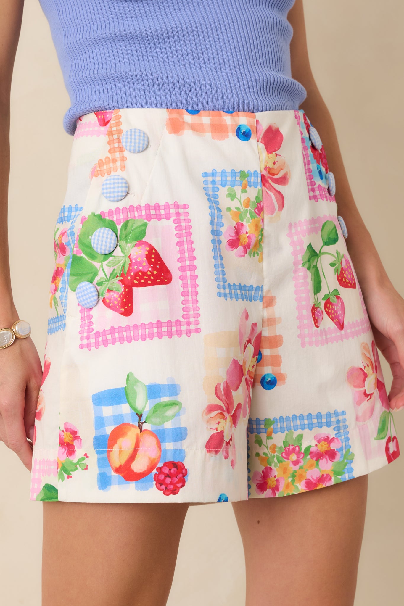 Close-up detail of the multi-color shorts highlighting the blue gingham-covered side buttons, stitched trim, and the crisp cotton fabric construction.