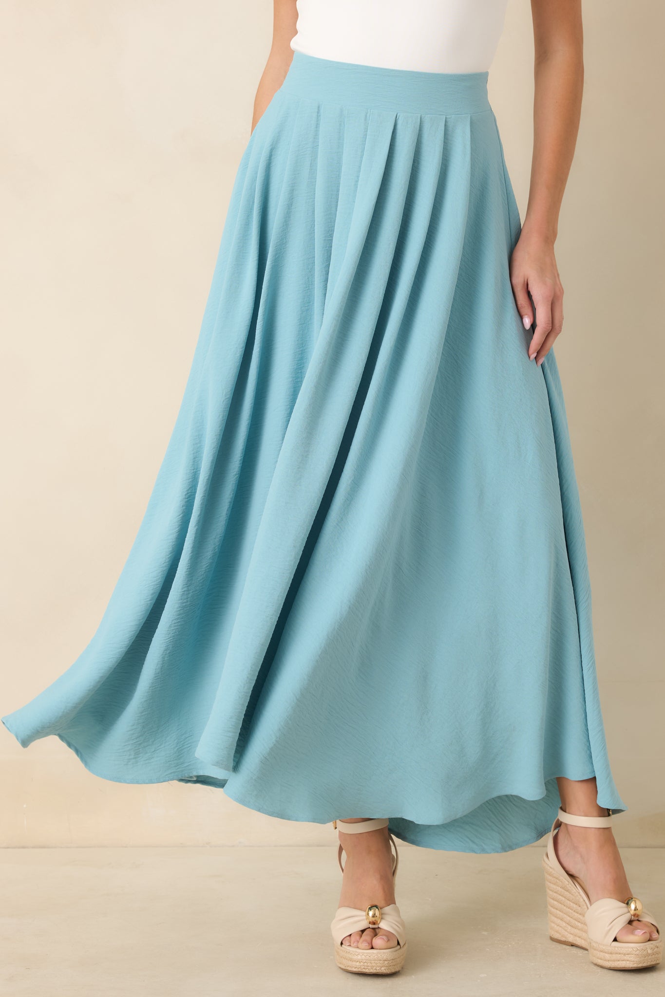 Turquoise full-length skirt showcasing lightweight movement, a gathered waistband, and elegant shape.