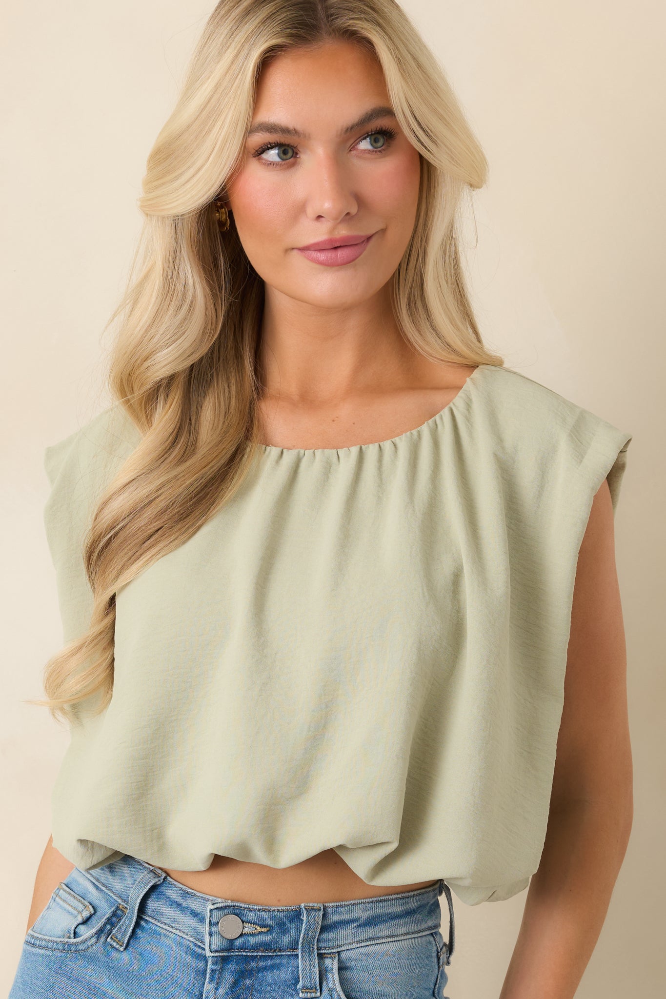 Lightweight fabric texture of sage green cropped top with soft drape.