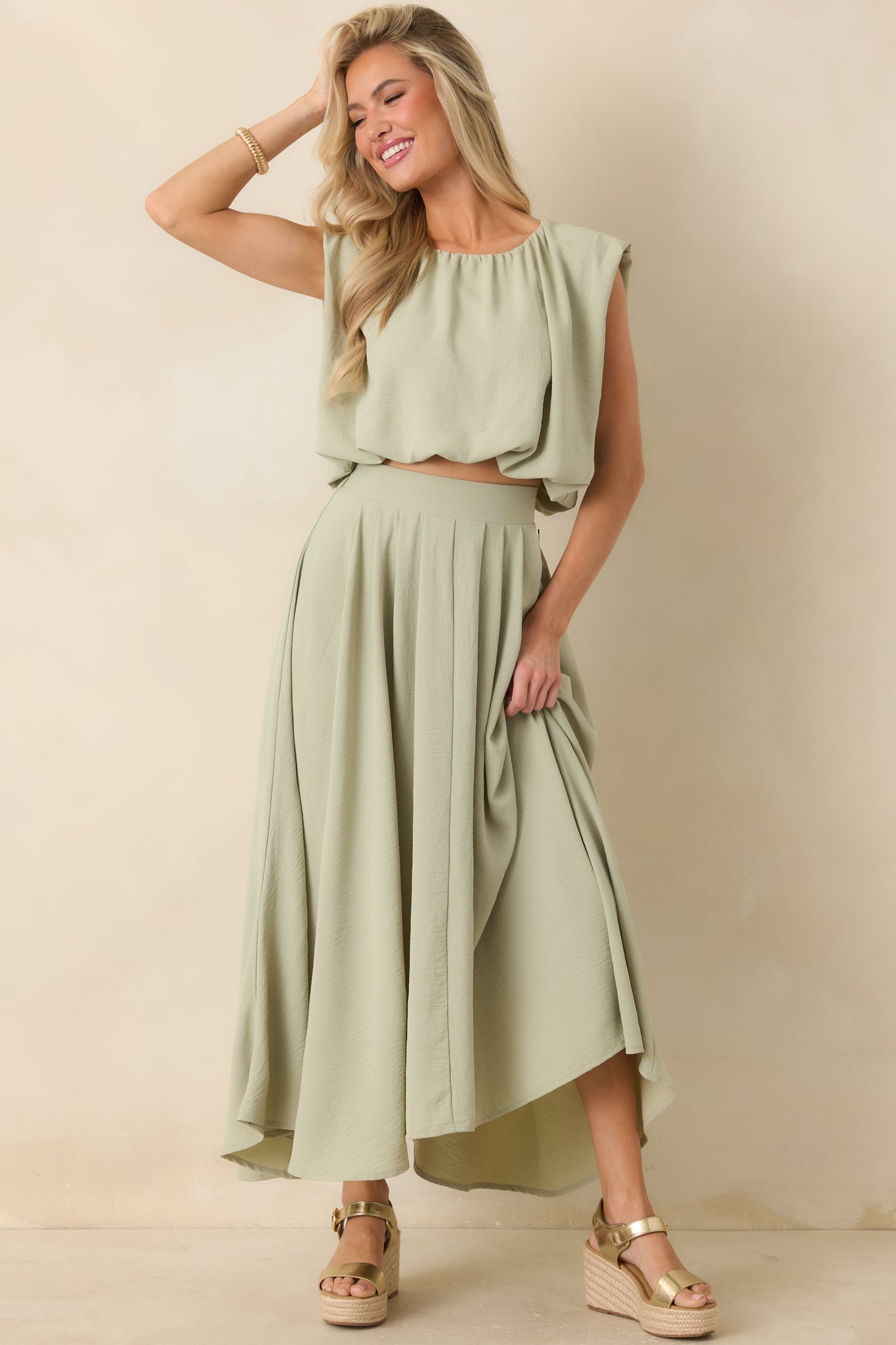 Relaxed sage green cropped top featuring elasticized hem and softly structured shape.