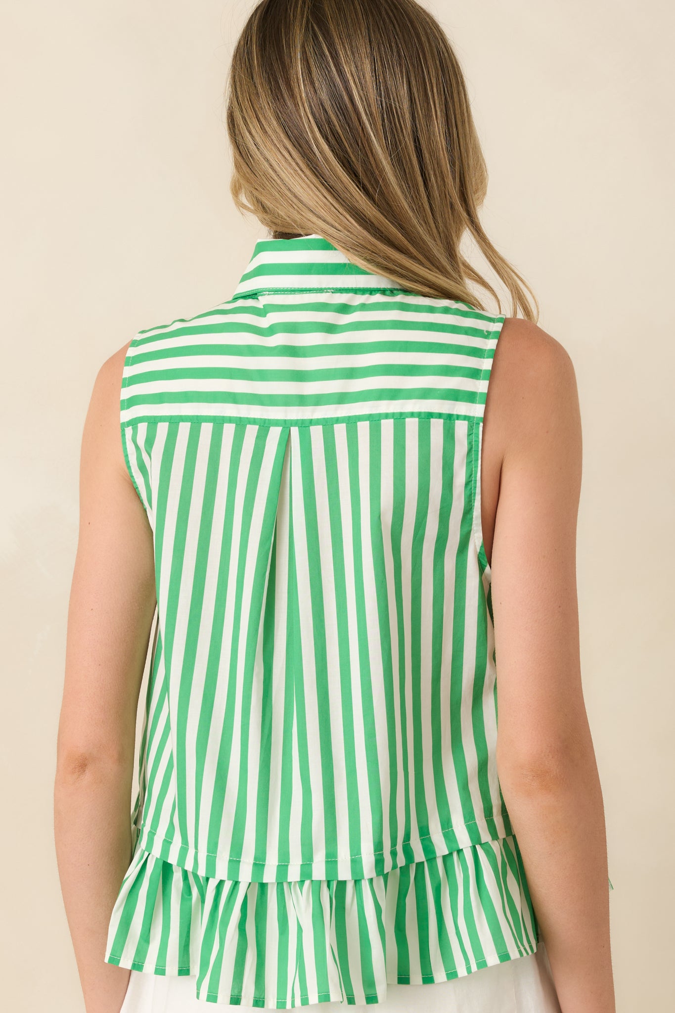 Rear view of sleeveless striped cotton top with ruffled hem and relaxed silhouette.

