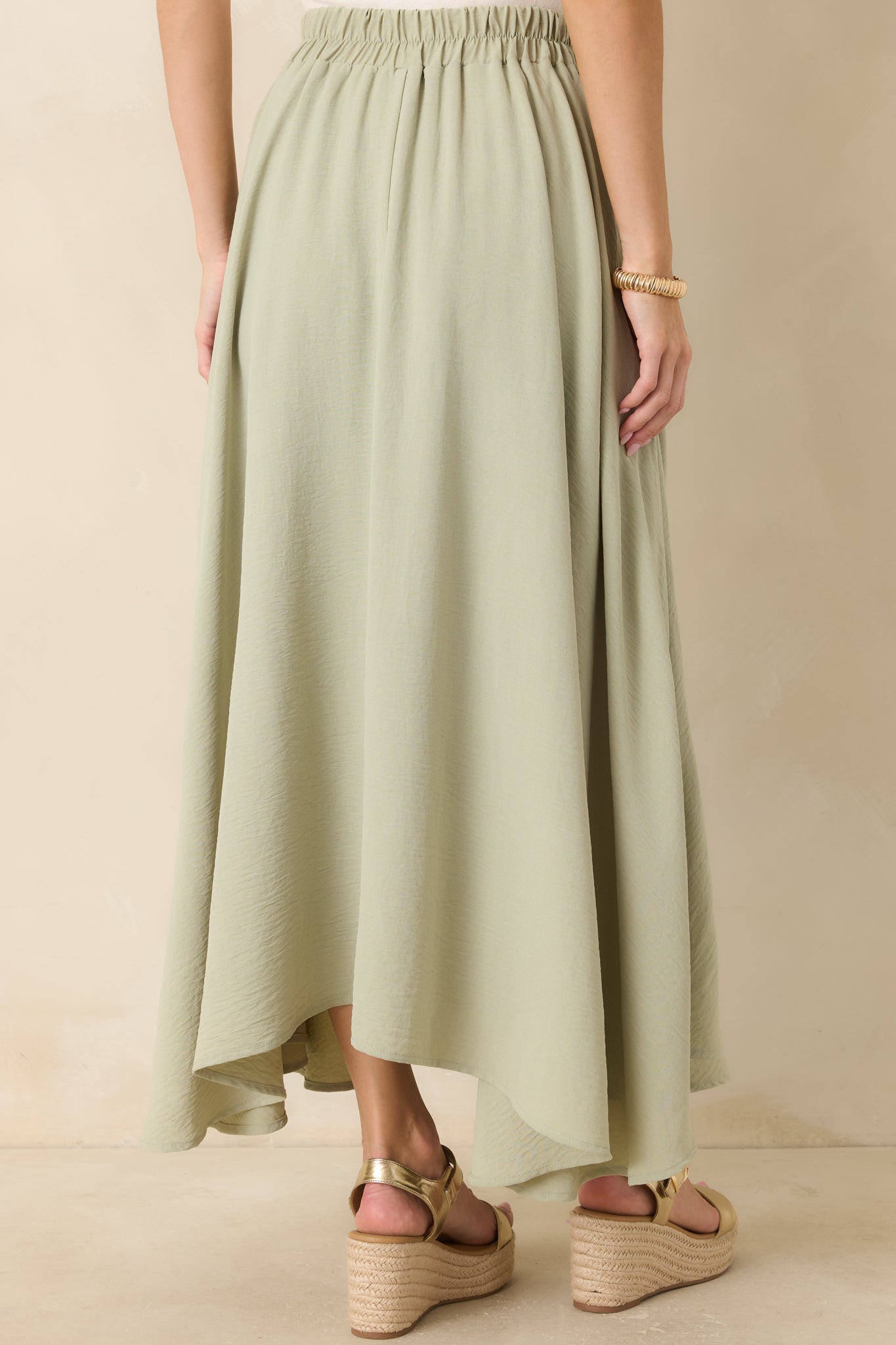 Rear view of sage green maxi skirt with flowy silhouette and full lining.