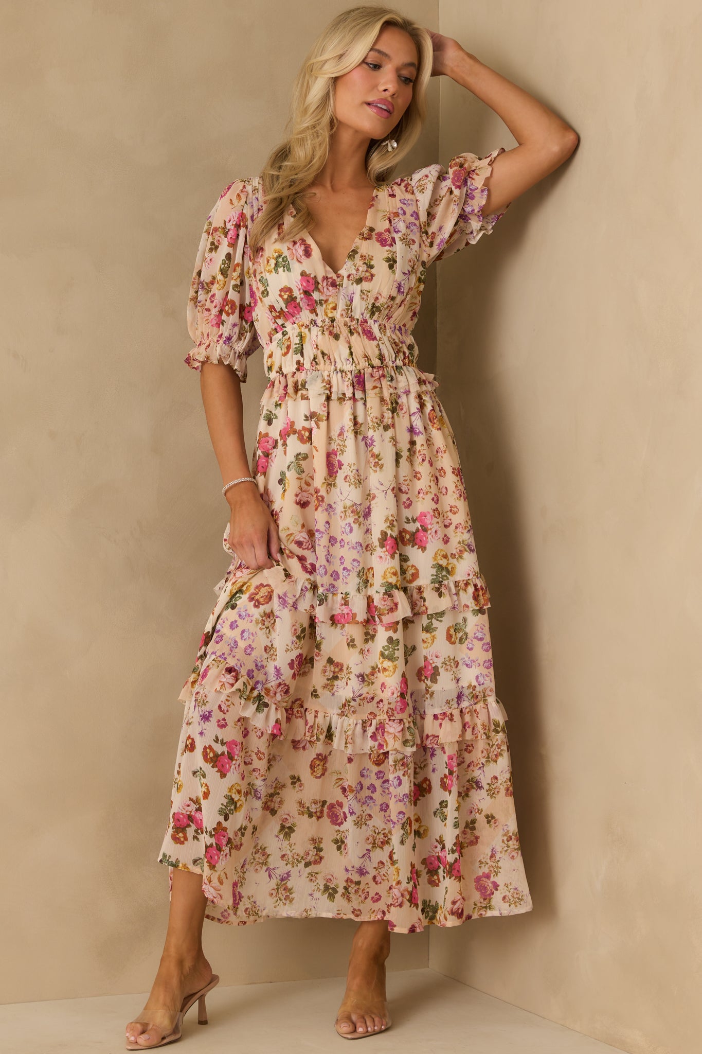 Beige midi dress with pink florals, puff sleeves, and ruffled tiered layers flowing from the elastic waist.