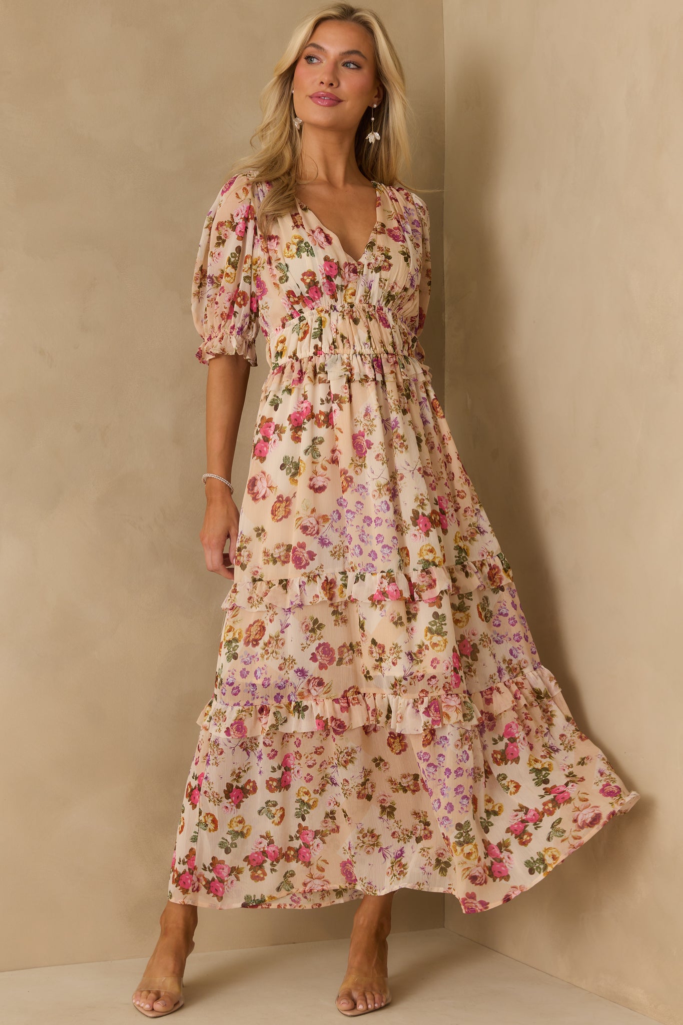 Pink floral print midi dress with v-neckline and soft ruffle trim accenting the tiered skirt.