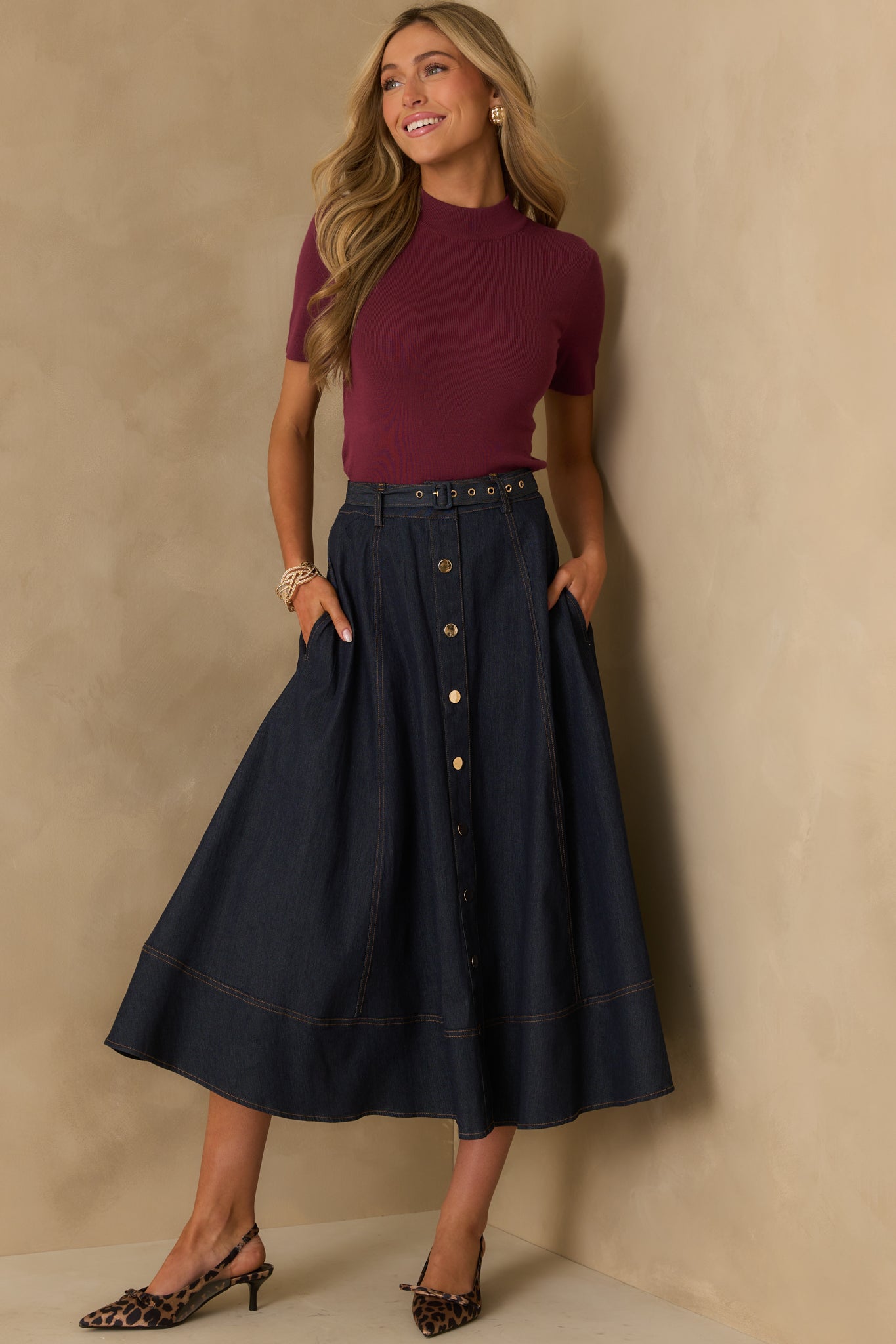 A full length image of the wine red knit top with short sleeves and a mock neck design.