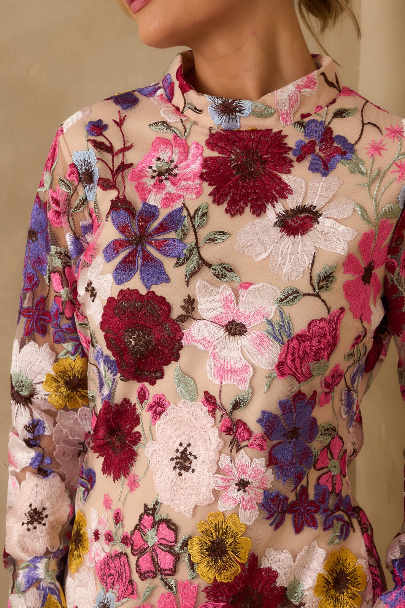 Detailed close-up of sheer floral overlay fabric and stitching on the mini dress.