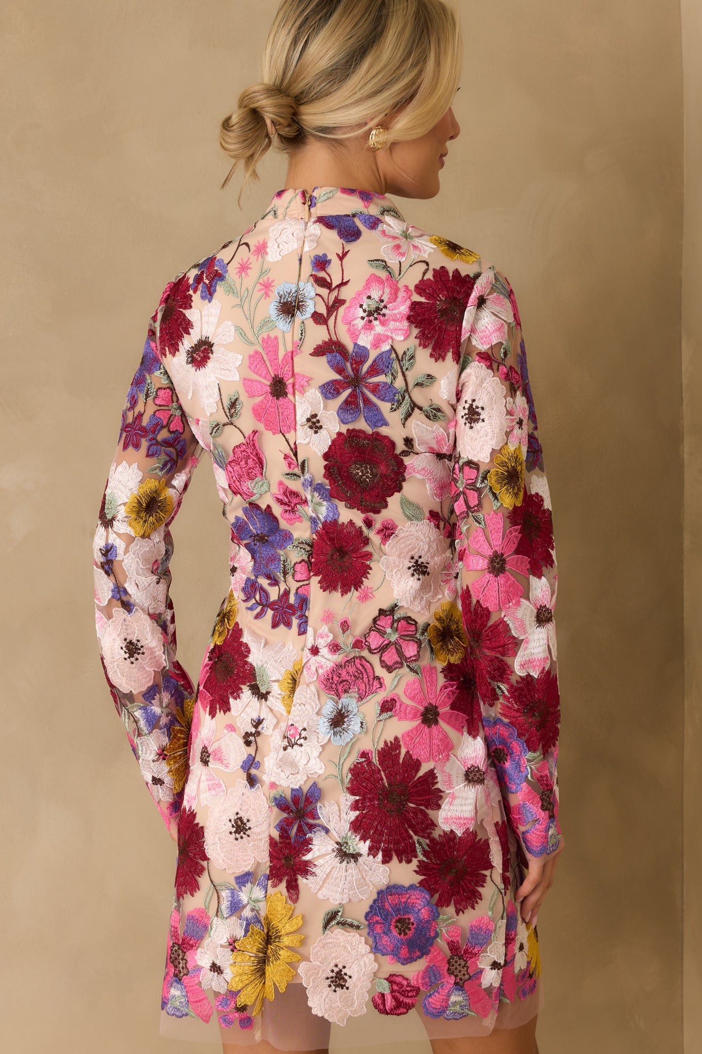 Rear view of mini dress showing discrete back zipper and sheer floral overlay continuing across the back.