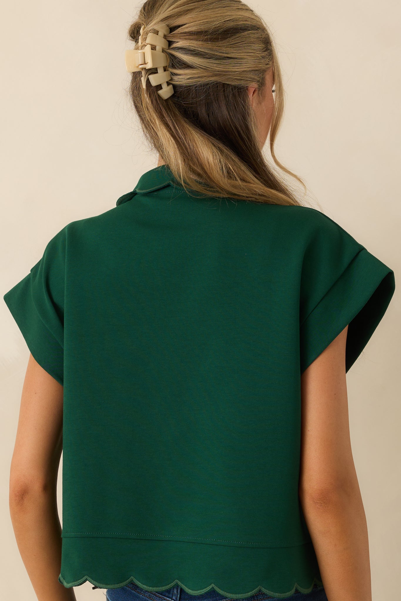 Rear view of the hunter green pullover with embroidered scallop hems and a relaxed fit.