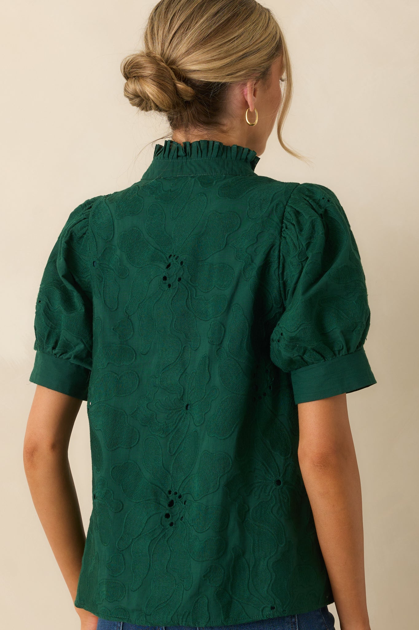 Rear view of the hunter green blouse showing the straight hemline and puff sleeve finish.