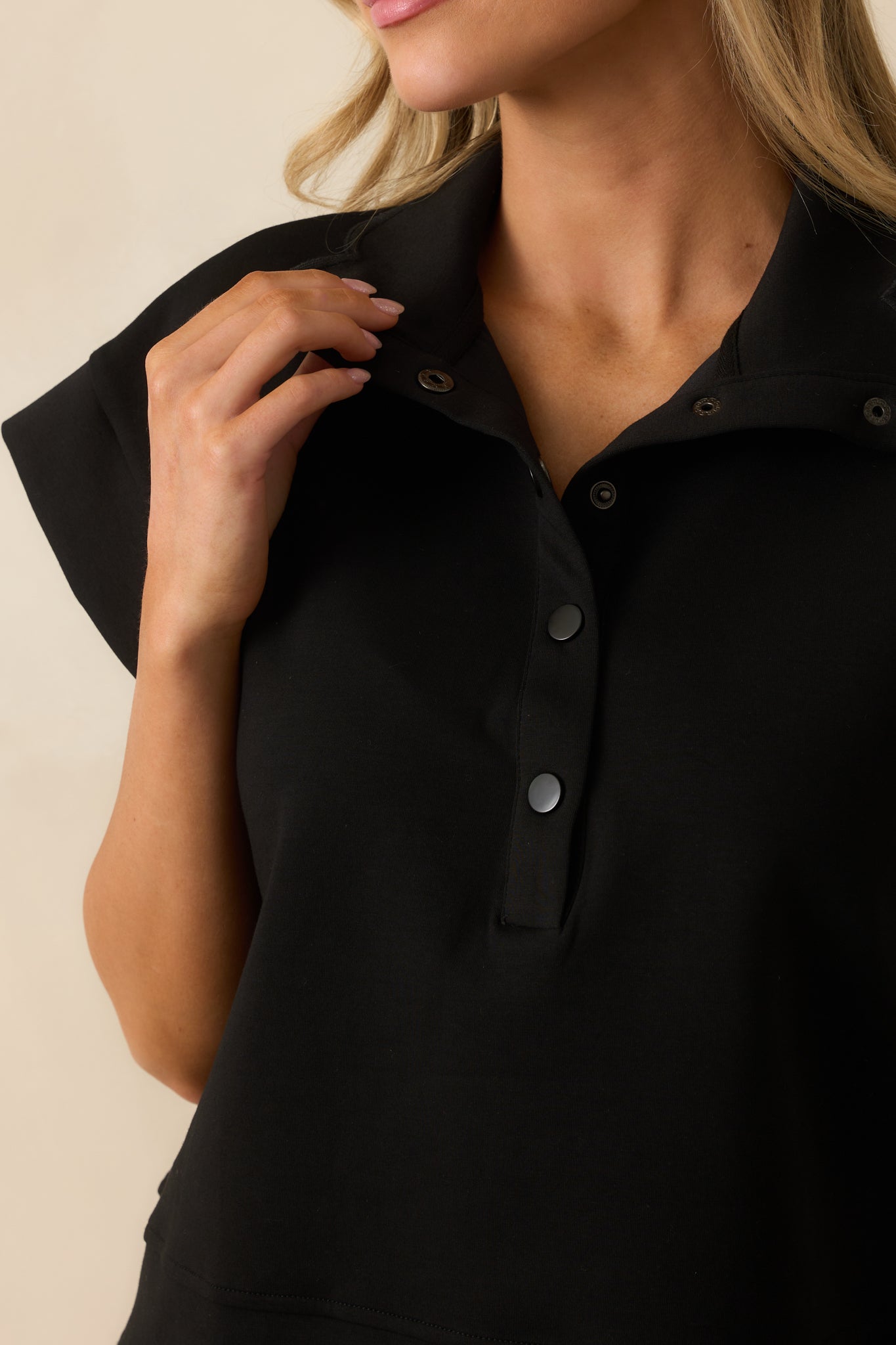 A detailed close-up of the collared neckline and functional half snap button front.