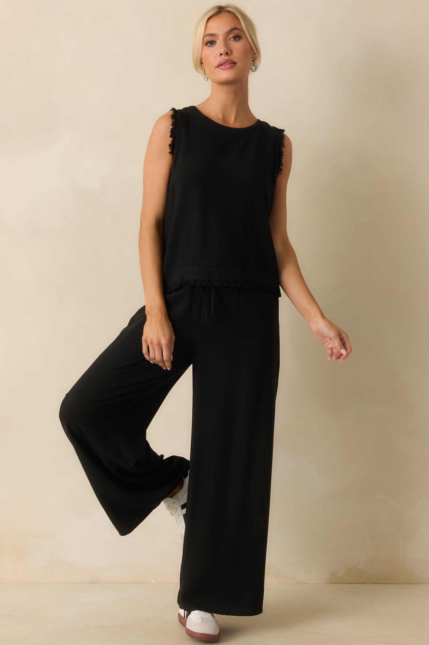 Casual black tank with frayed detailing along shoulders and bottom edge.