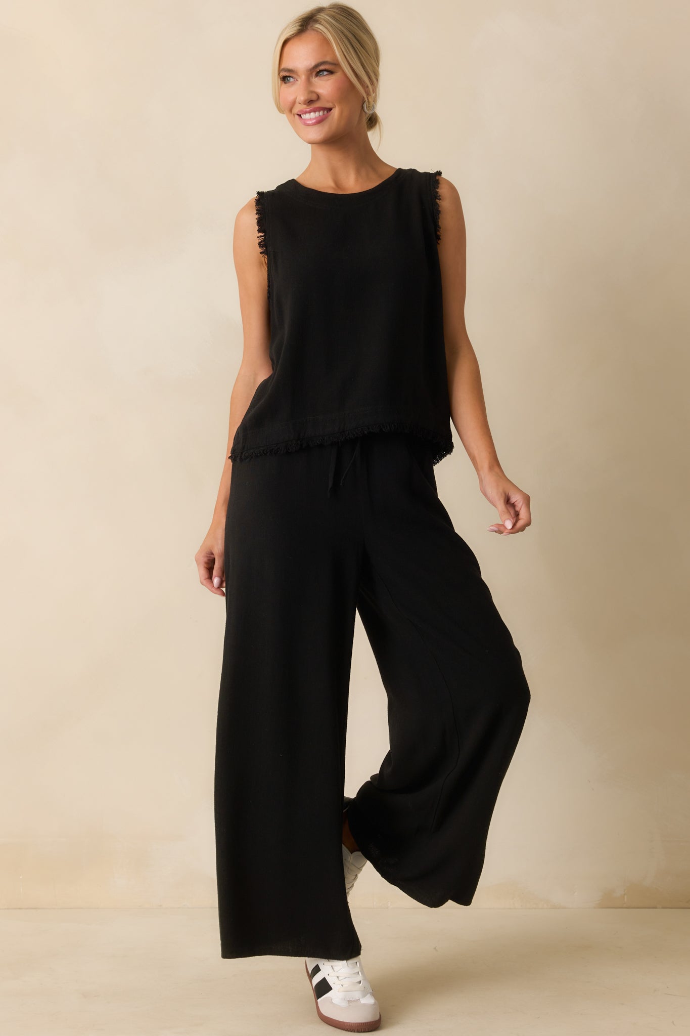 Relaxed-fit black top highlighting crew neckline and edgy frayed trim.