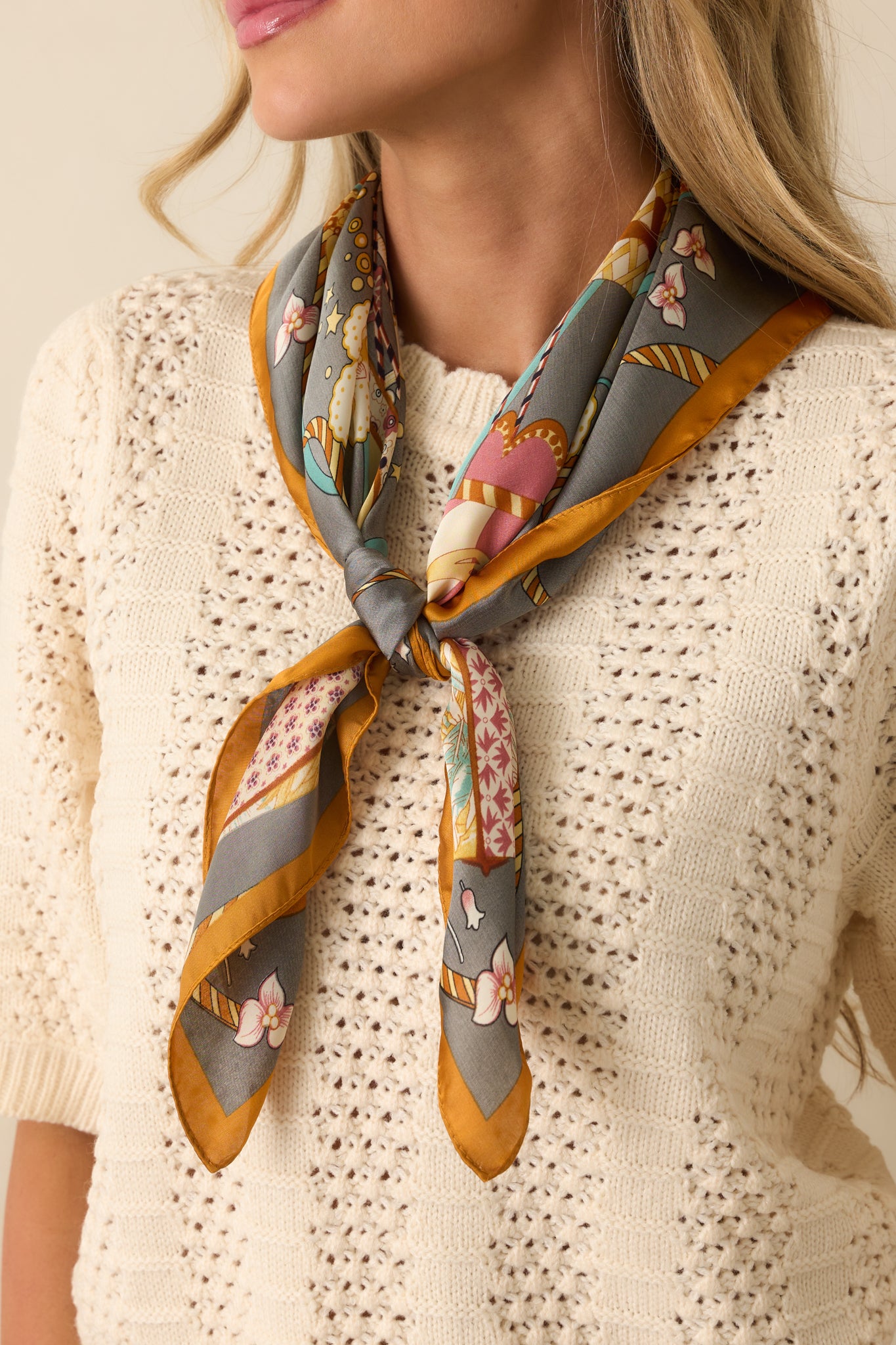 A shot of the scarf styled loosely around the neck, highlighting the golden border and colorful hot air balloon pattern.