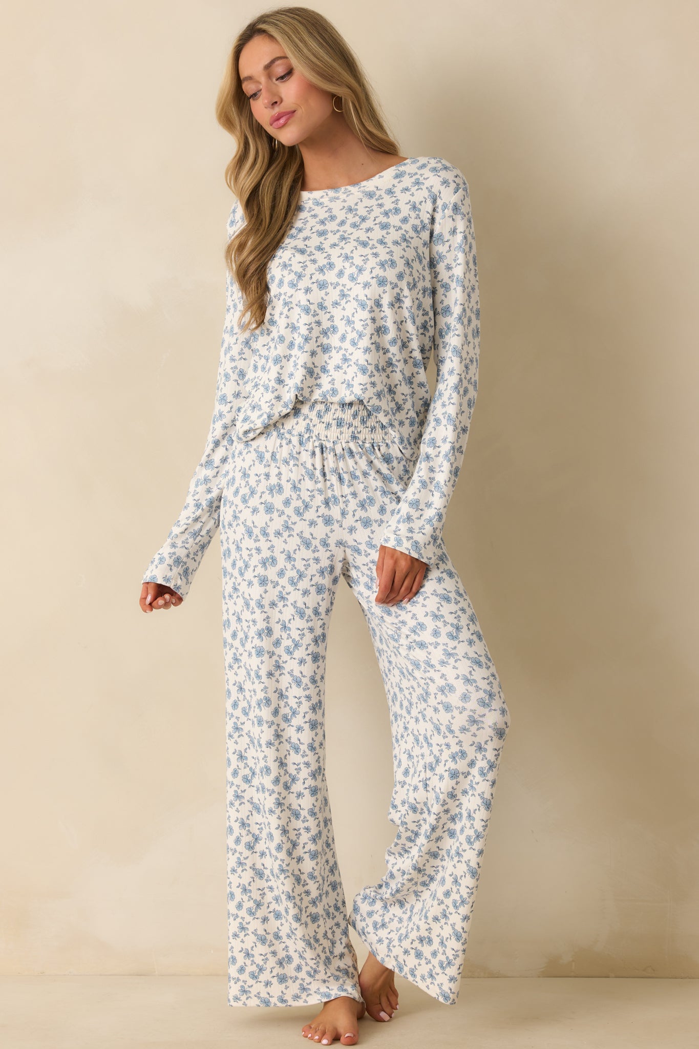 Relaxed fit pants featuring an ivory base with blue blooms and a wide leg silhouette.