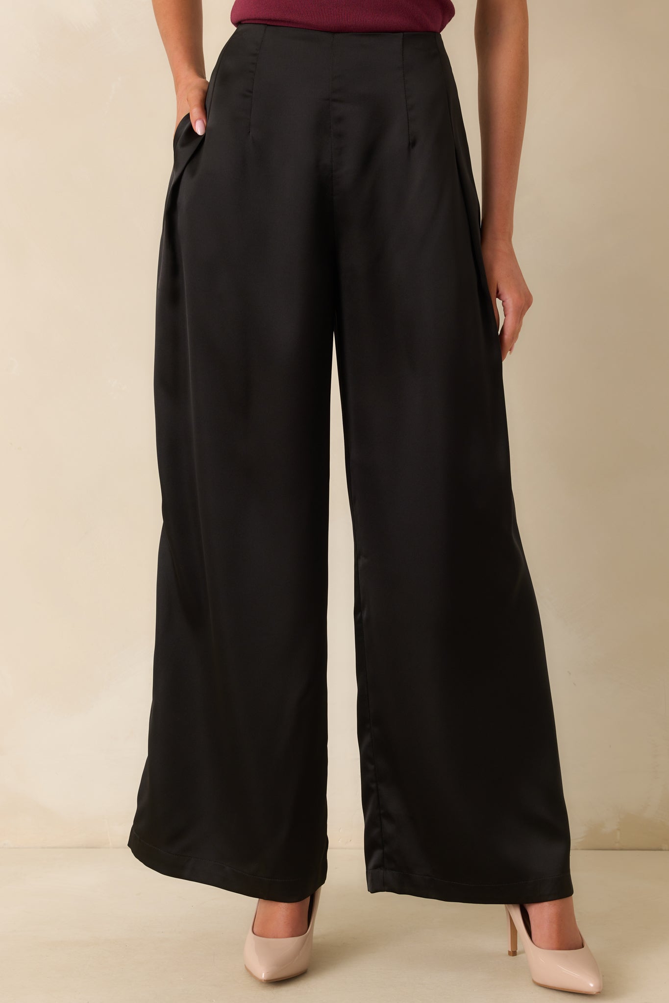 A cropped front view focusing on the waistband and sleek satin finish of the pants.