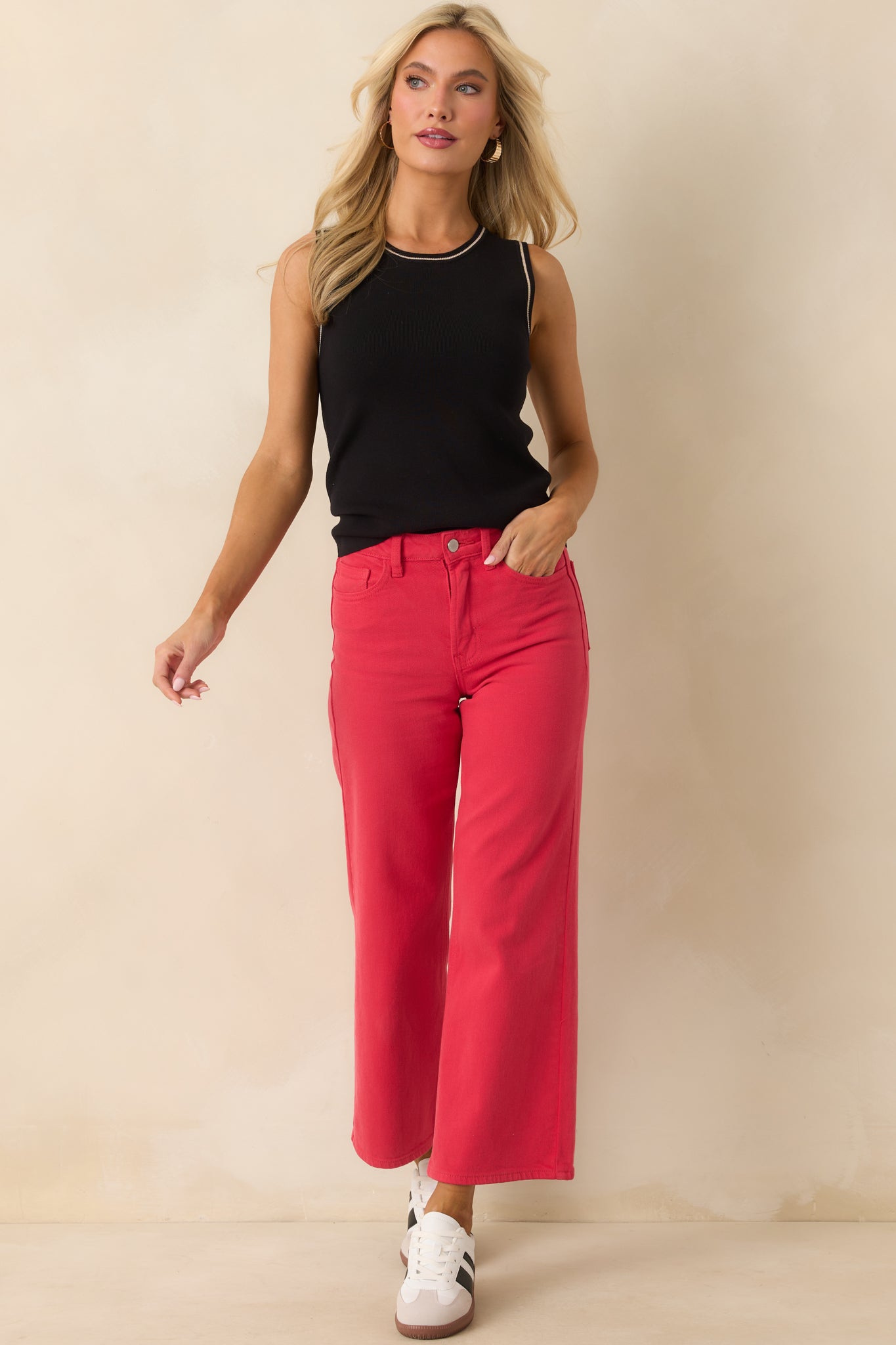 Red jeans displayed in full, showing functional front and rear pockets with a tailored finish.