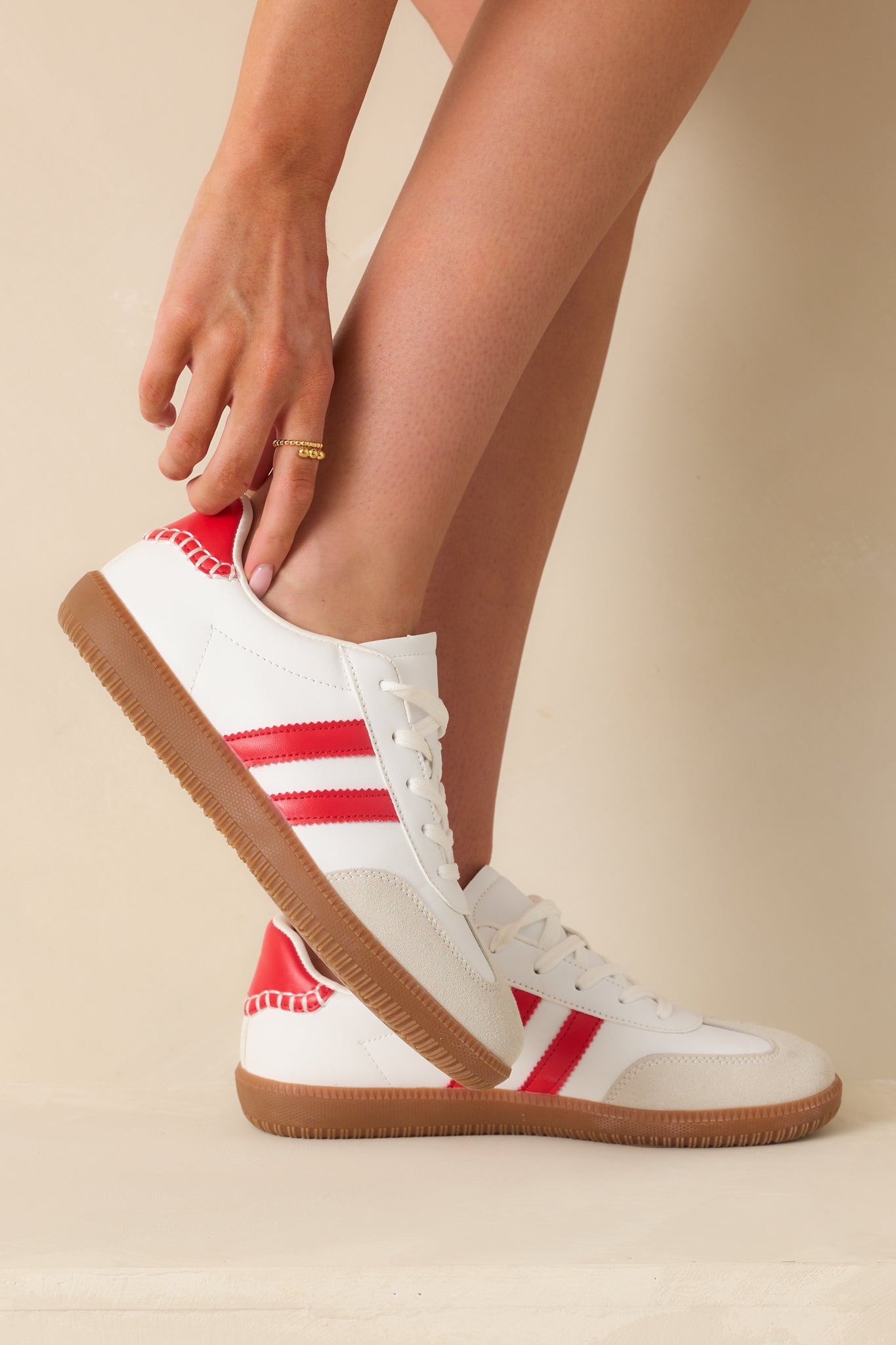 Sneakers displayed slightly tilted, emphasizing the contrast of the red details against the white body.