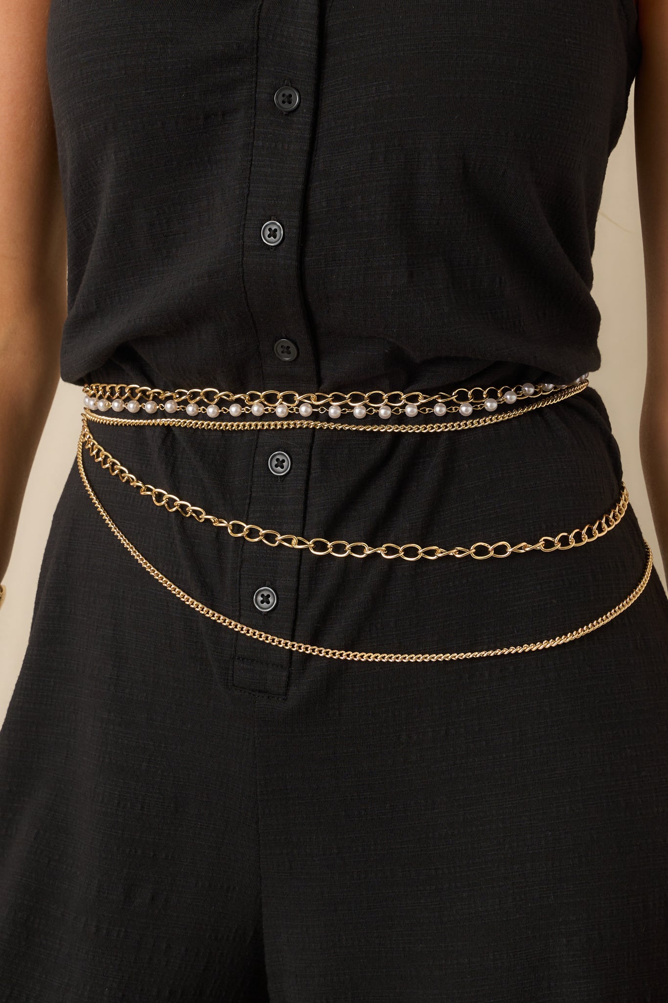 Detailed shot highlighting the combination of gold chains and faux ivory pearls in the layered design.