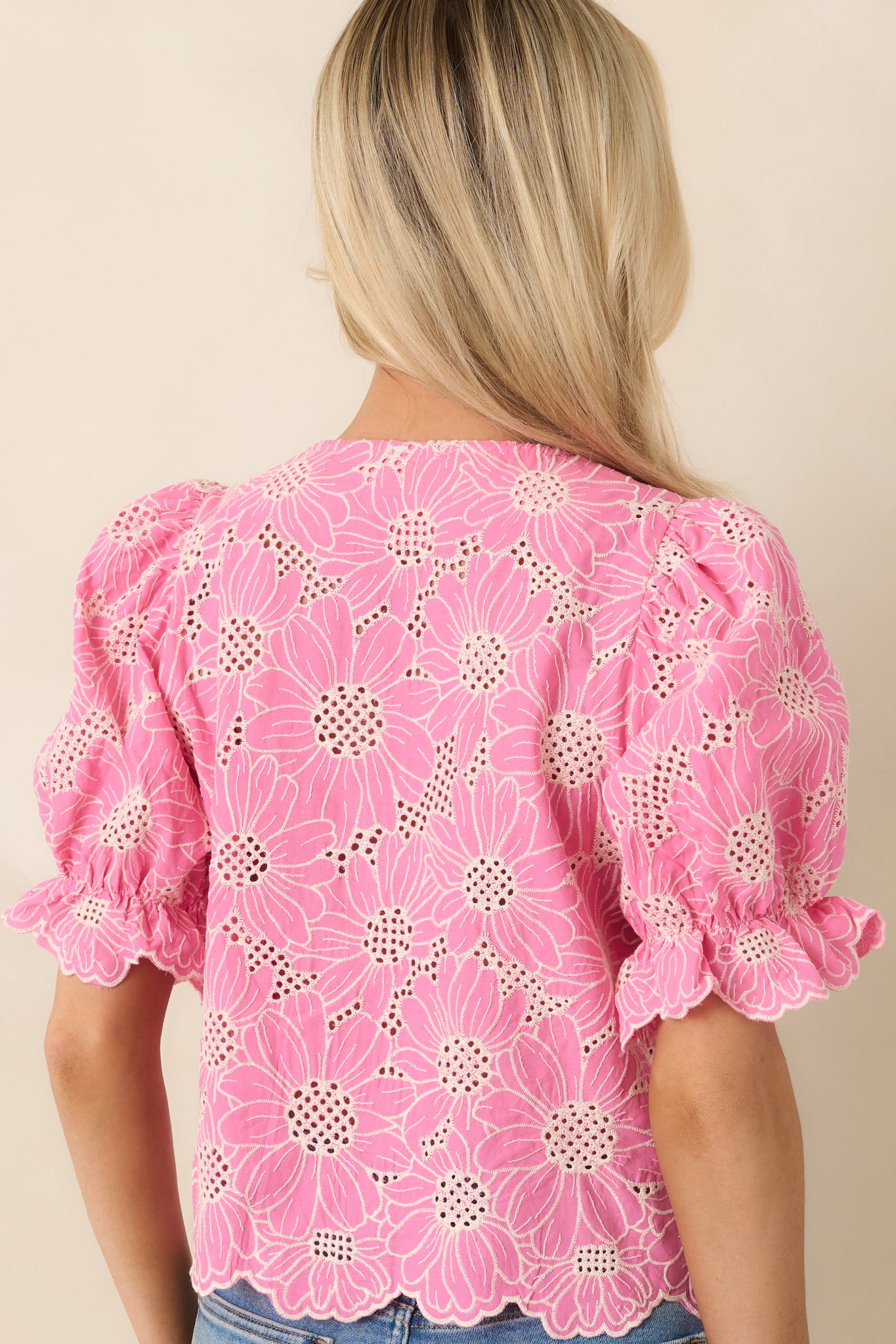 Rear view of the embroidered top with puff sleeves and smooth back finish.