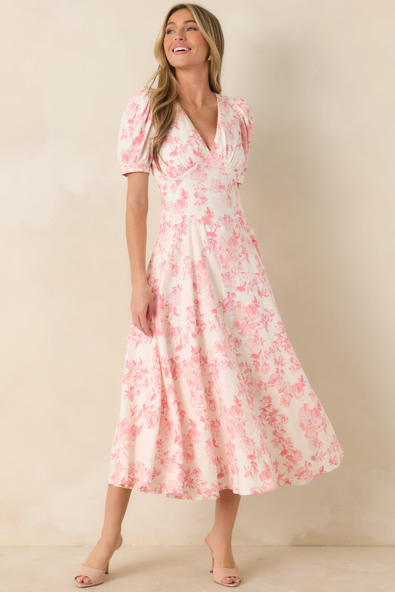 Coral pink floral maxi dress with paneled bodice, short puff sleeves, and flowing draped silhouette.