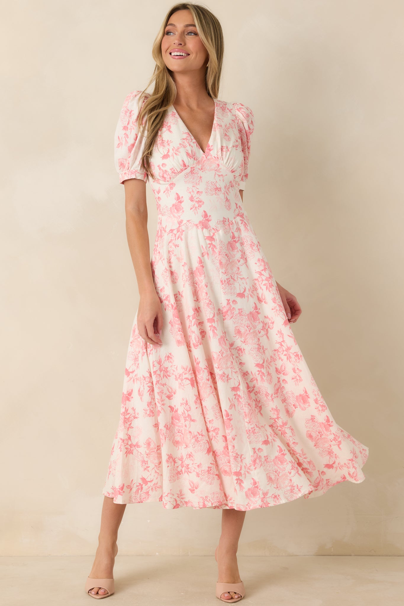 Coral pink maxi dress with floral print, paneled bodice structure, and breezy flowing skirt.