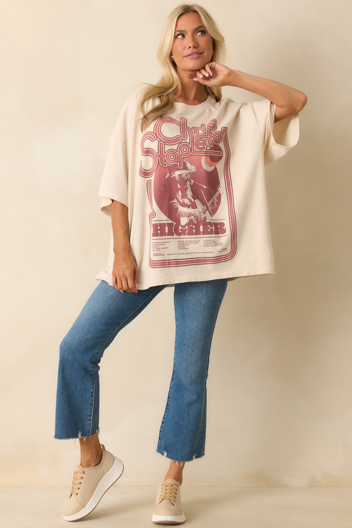 Classic crewneck ivory tee with a front tour graphic in maroon tones and short sleeves.