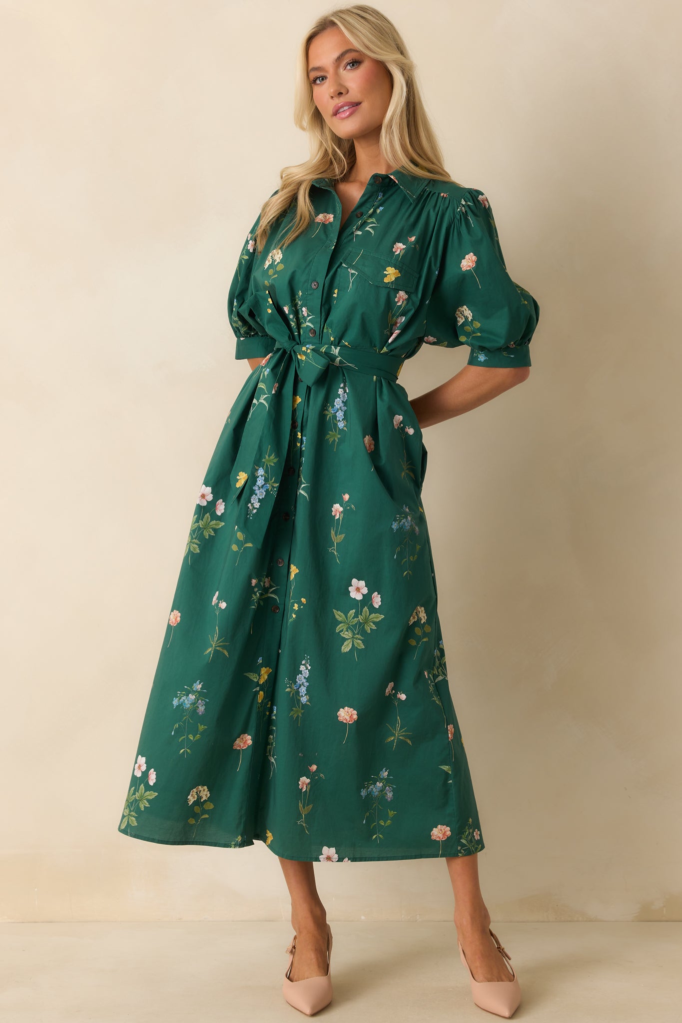 Forest green dress showing puff sleeves, floral print, and button-down front details.