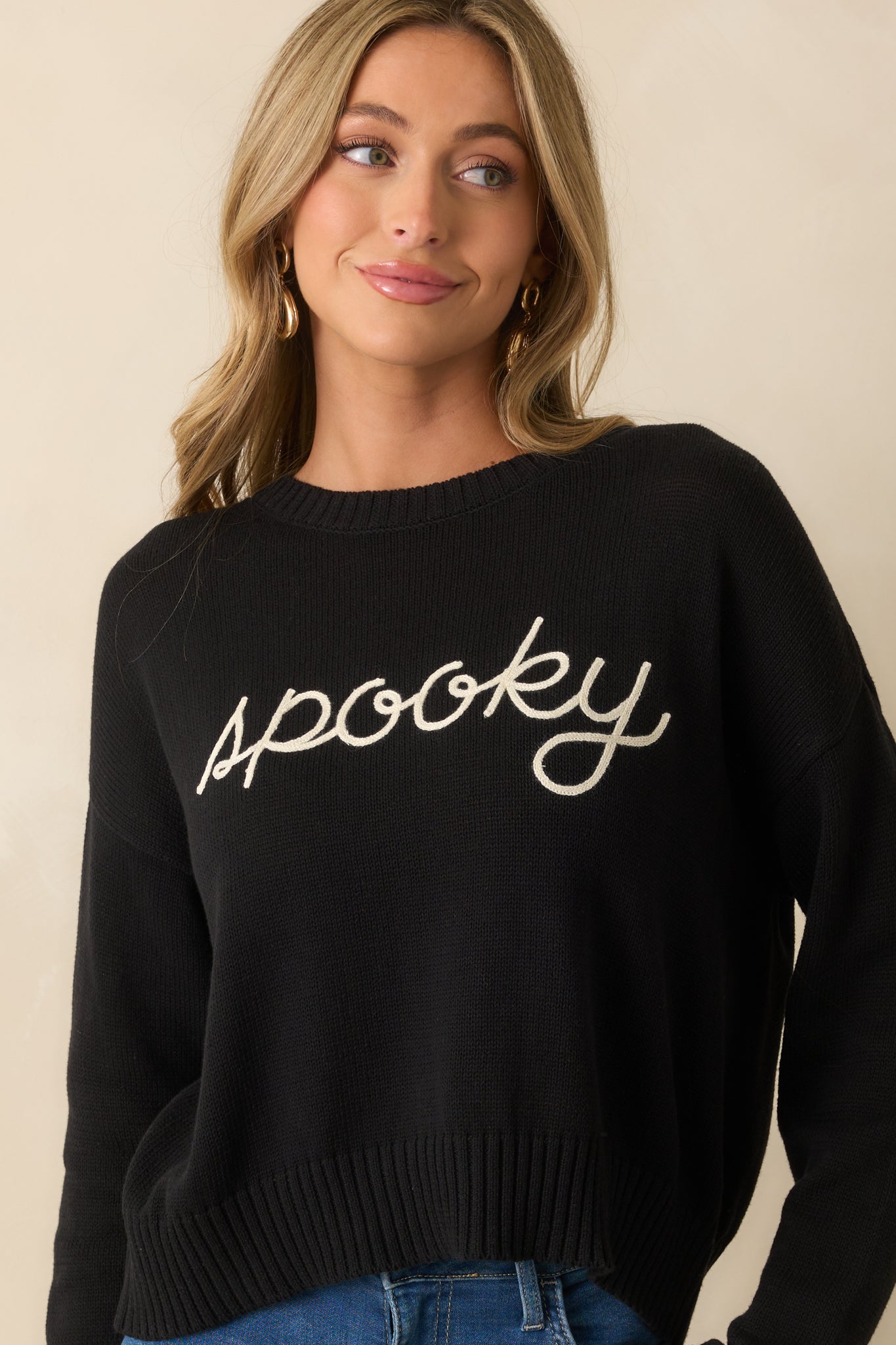 Crew neckline of the sweater framed by soft knit texture.