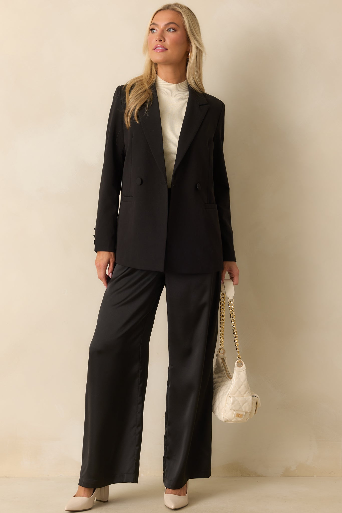Black blazer with classic lapels and structured silhouette, showing subtle shaping.