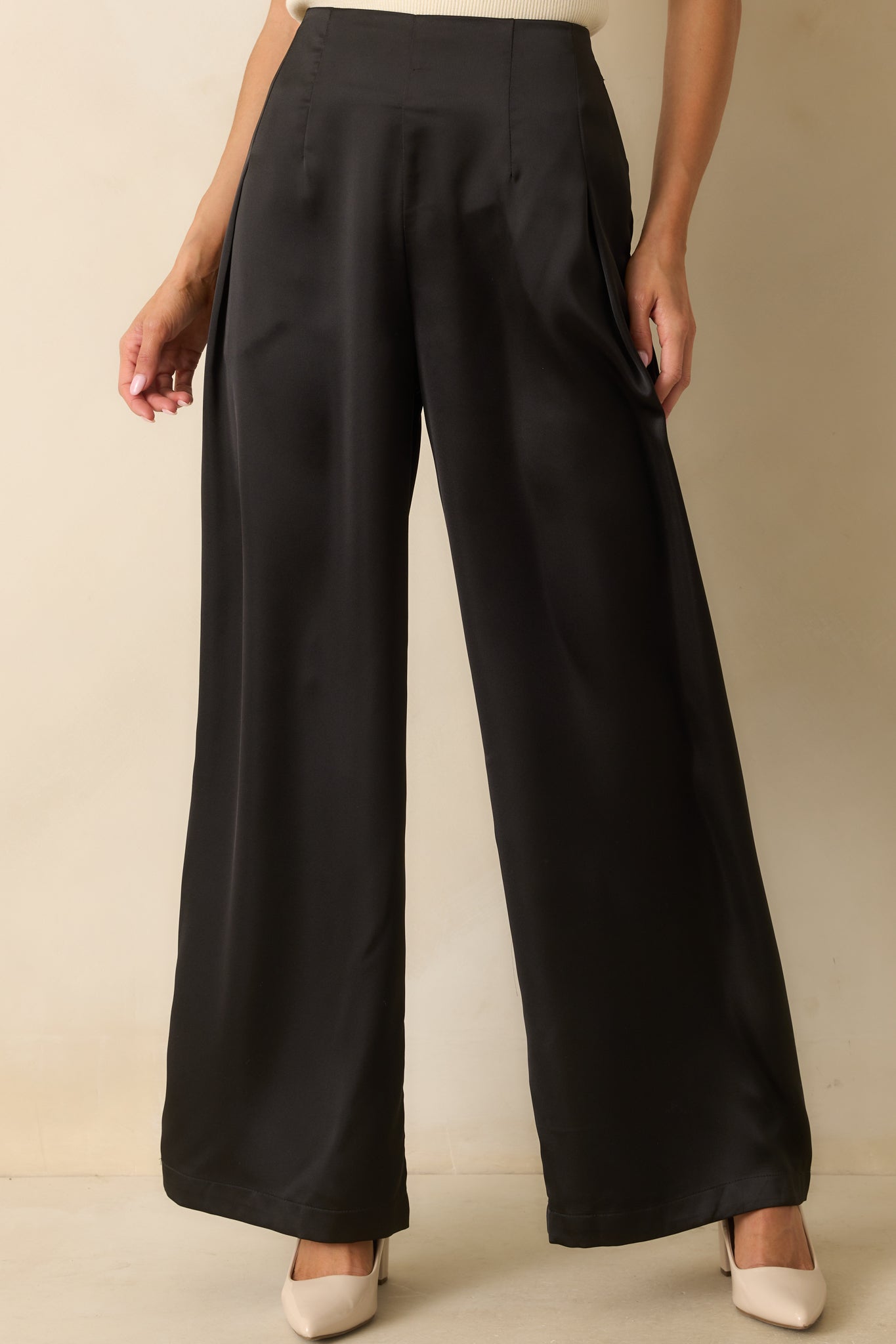 Cropped view highlighting the high waistline and flowing leg silhouette of black pants.