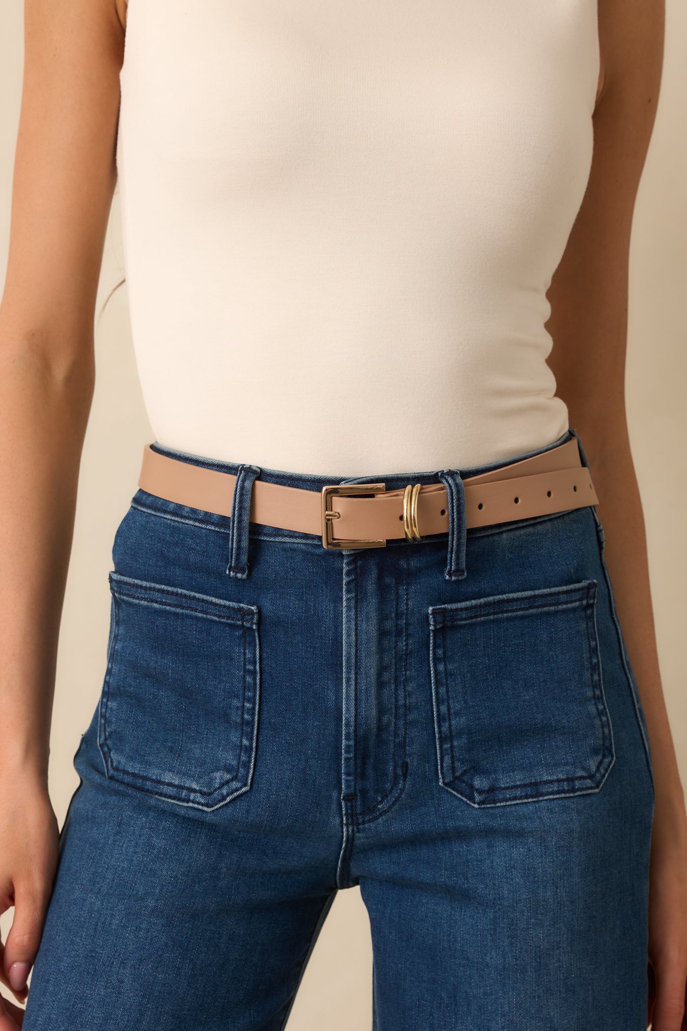 Beige slim belt with polished gold-tone square buckle and double metal loop detail.