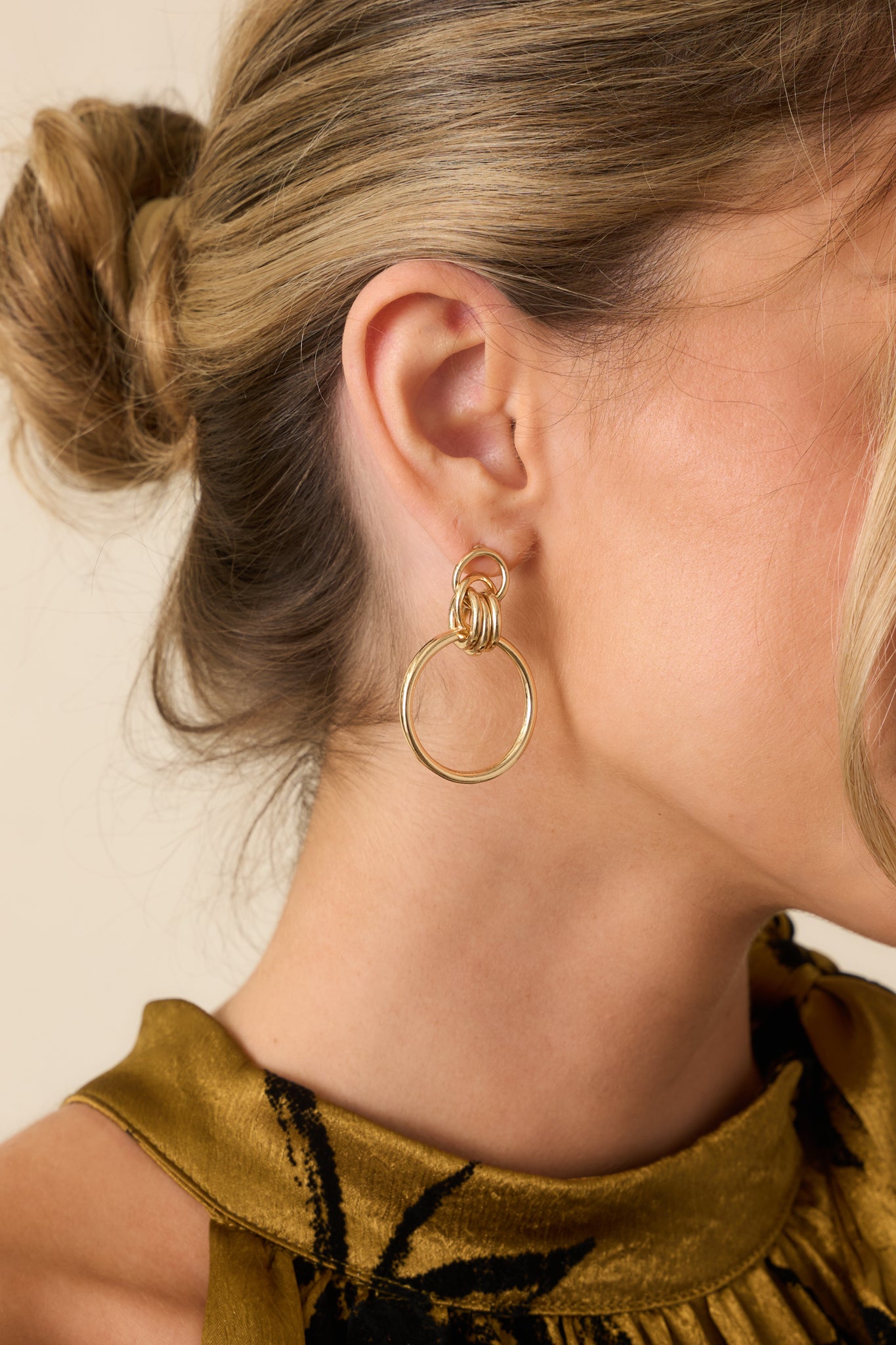 Gold-colored earrings featuring a hollow circle stud, three interlocking links, and a larger circular drop piece shown from the front.