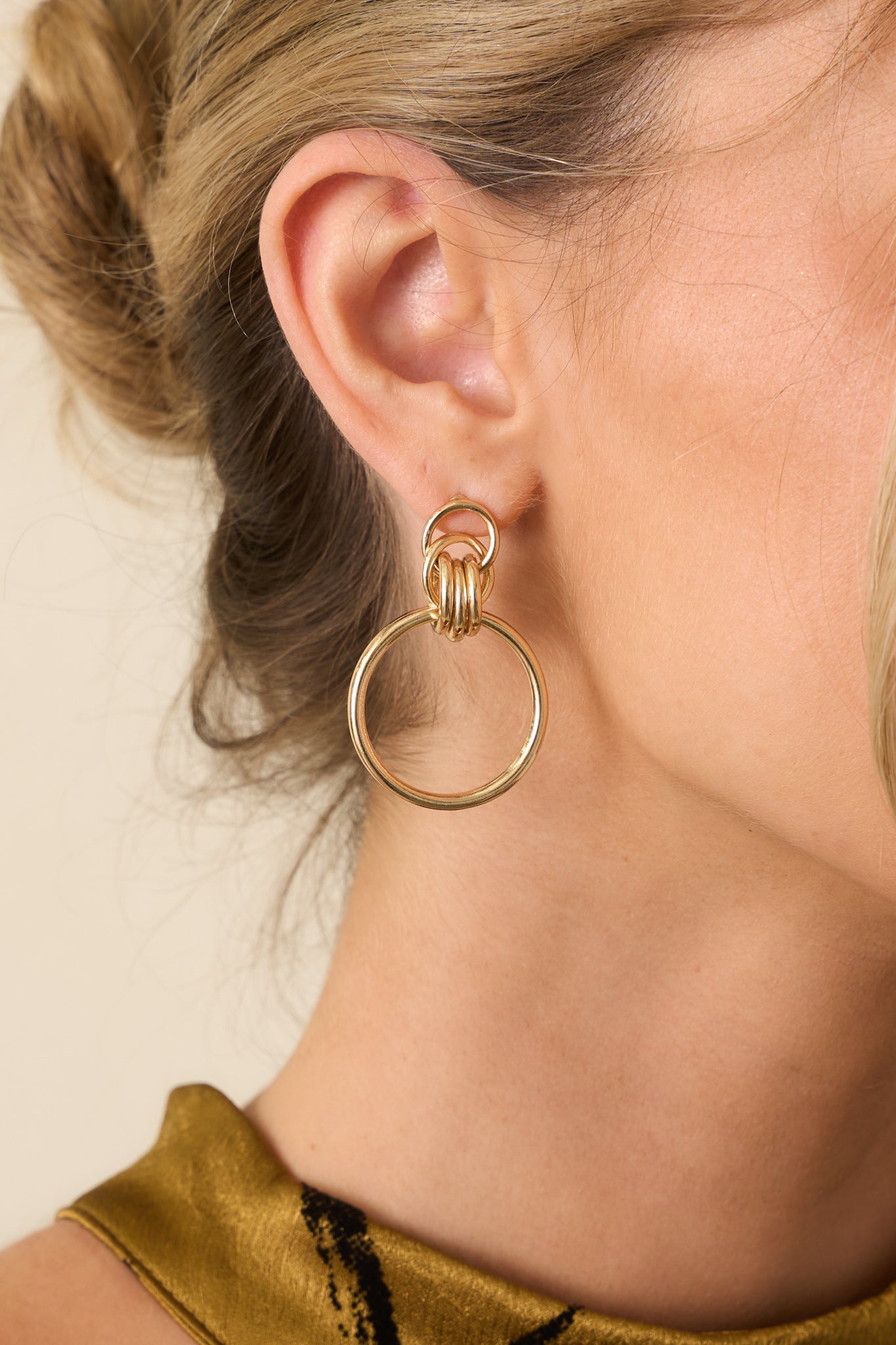 Detailed close-up showing the three interlocking links, larger circular drop, and secure post backing.