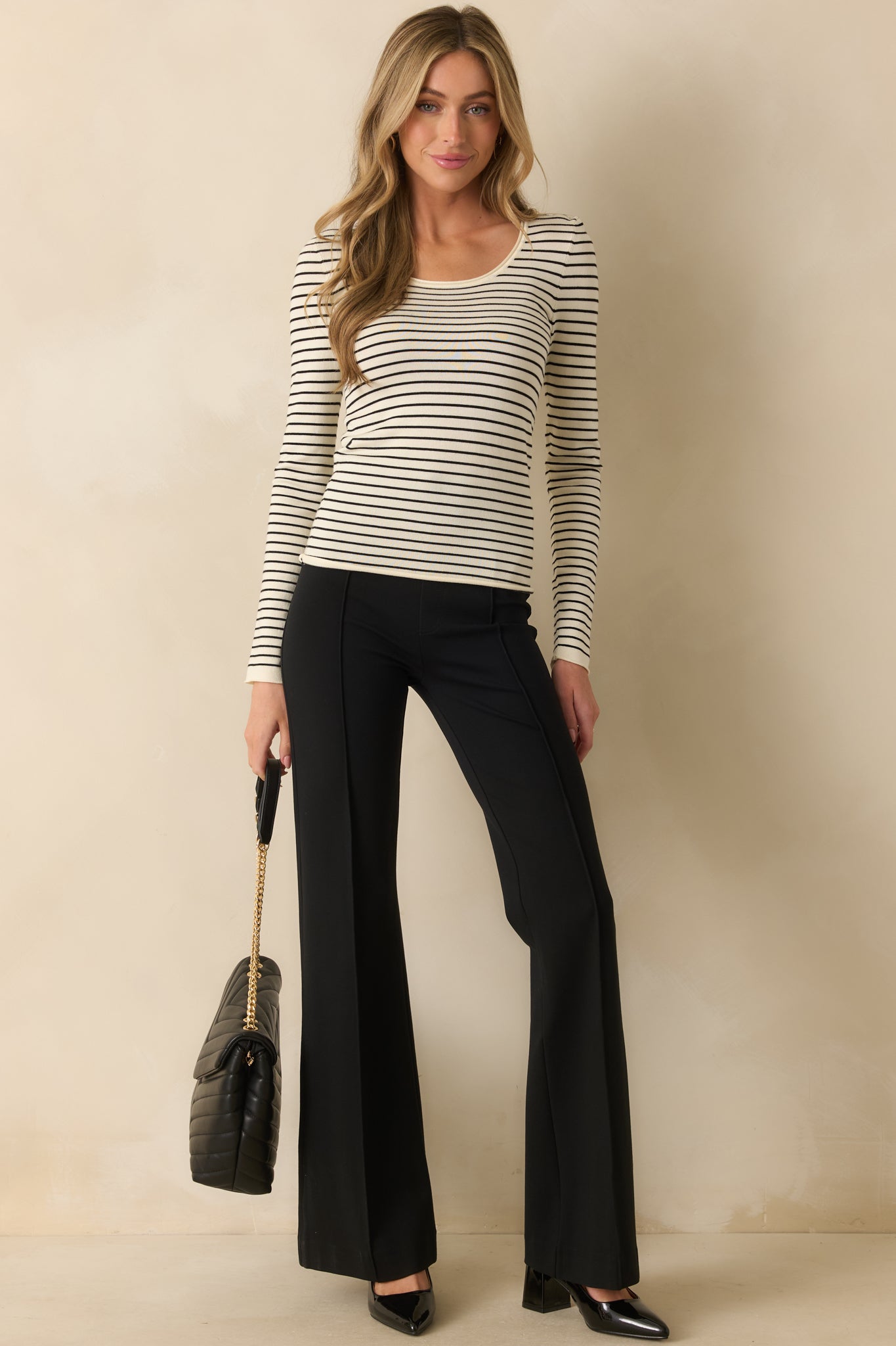 Ivory top with black stripes, long sleeves, and a relaxed, cozy fit.