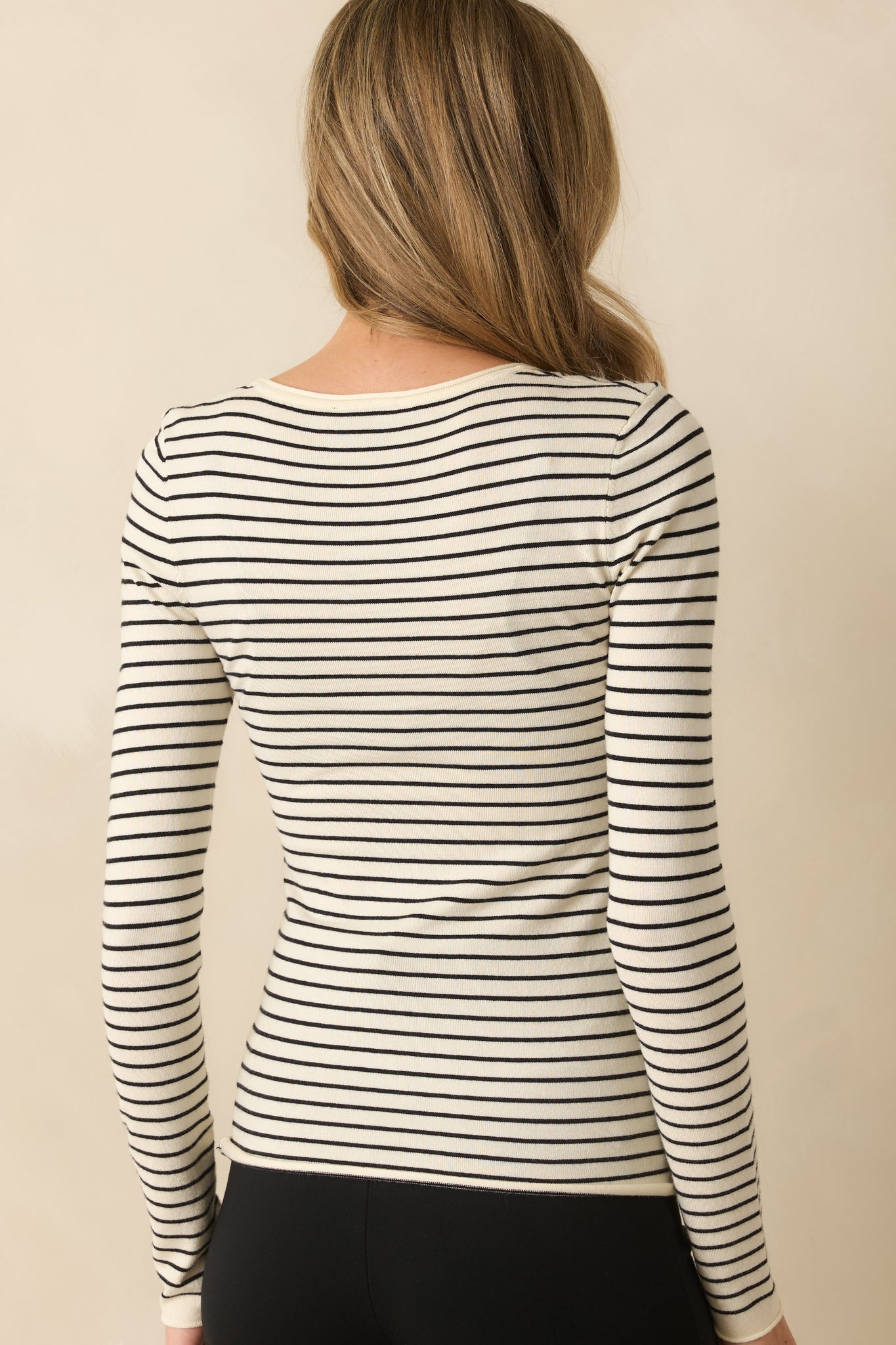 Rear view of ivory top highlighting the stripe design and long sleeve silhouette.
