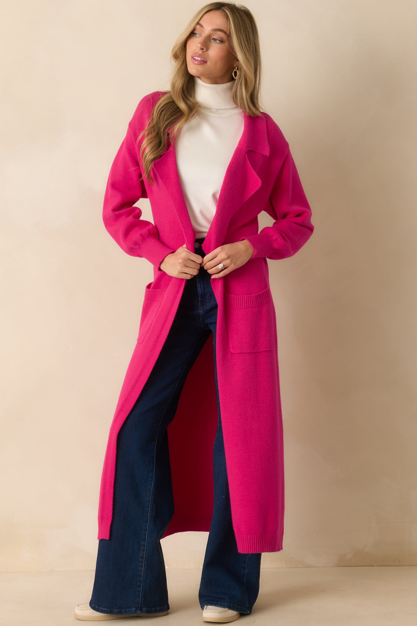 Hot pink longline cardigan highlighting the functional front pockets and relaxed fit for a polished look.