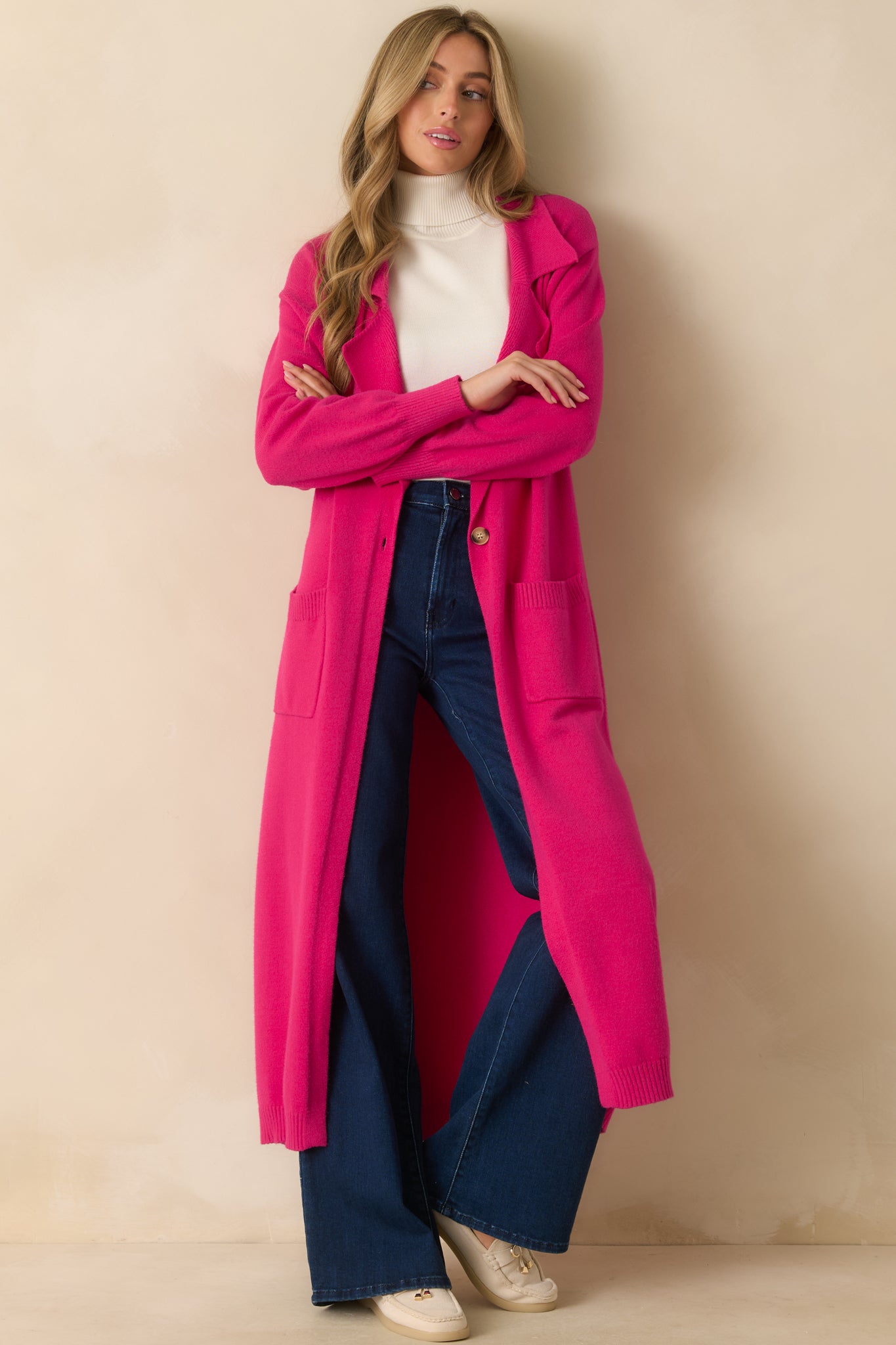 Full view of the cardigan showing the longline cut and smooth drape of the vibrant pink knit.