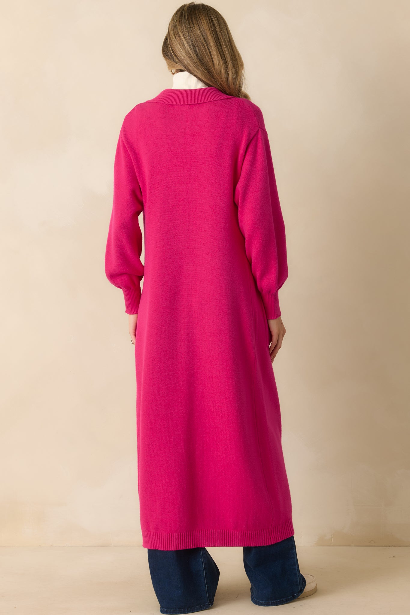 Rear view of the hot pink longline cardigan highlighting the straight hem and relaxed back silhouette.