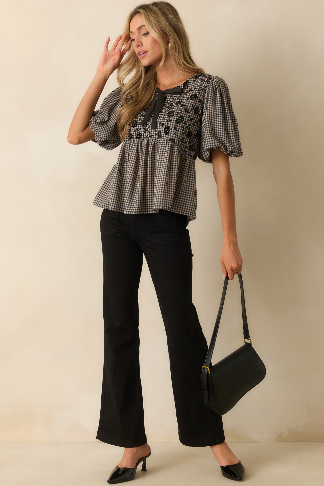Black and ivory gingham top highlighting the textured velvet floral accents and flowy peplum shape.