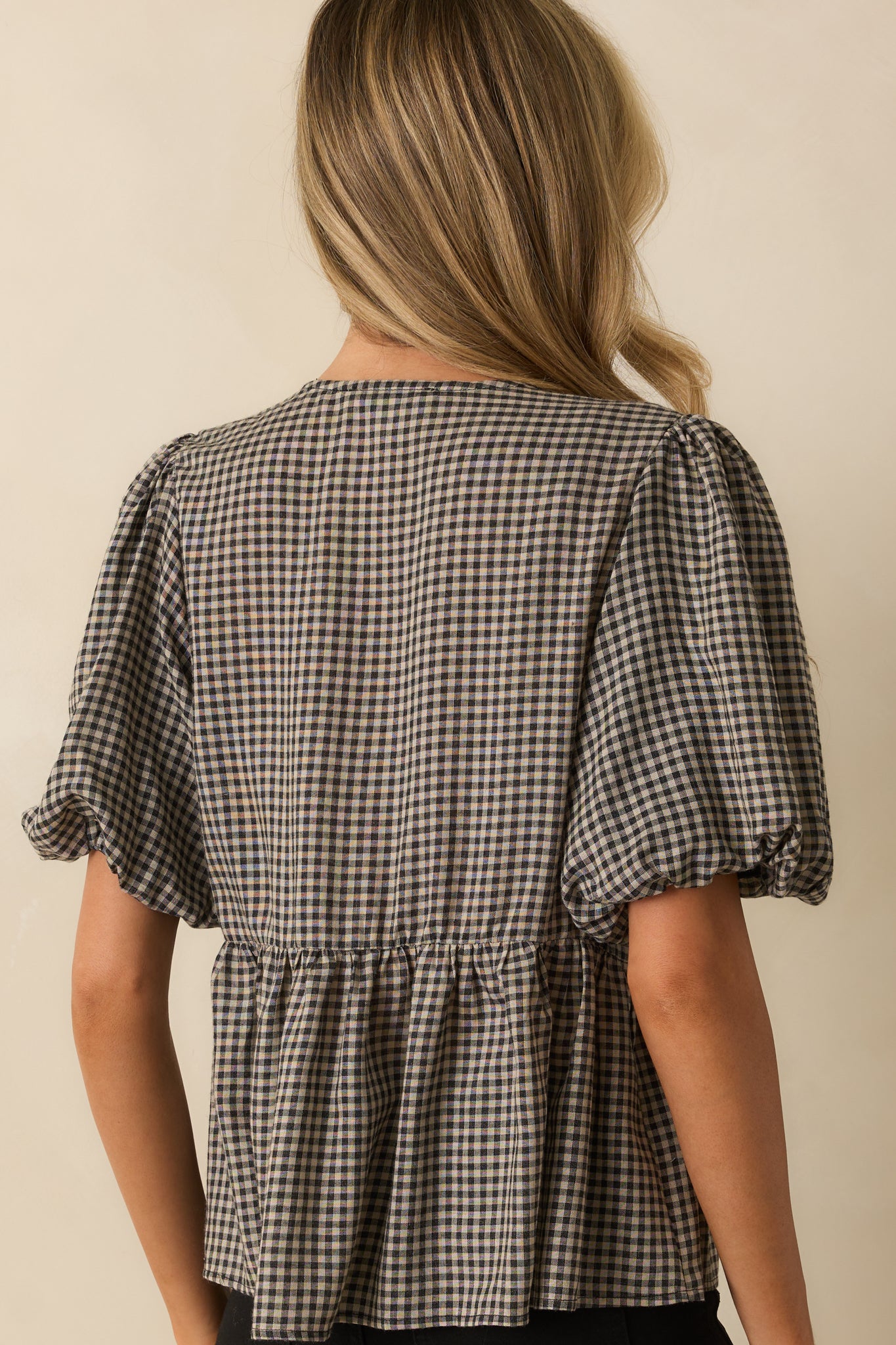 Rear view of the gingham top showing the straight back panel and peplum hem.